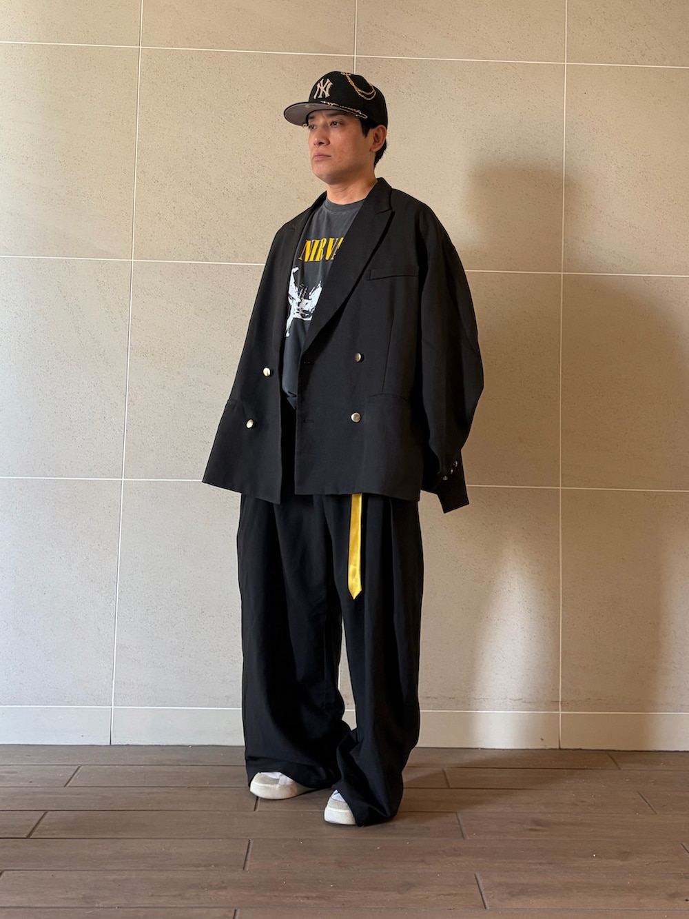グレー系のTシャツ/カットソー、ブラック系のテーラードジャケット、ブラック系のスラックスを着用したメンズの春コーディネートの2枚目の写真