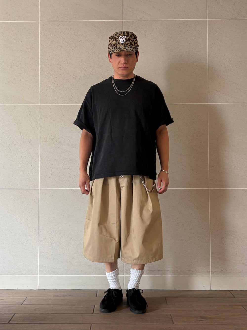 ブラック系のTシャツ/カットソー、ベージュ系のその他パンツ、ブラック系のモカシン/デッキシューズを着用したメンズの夏コーディネートの2枚目の写真