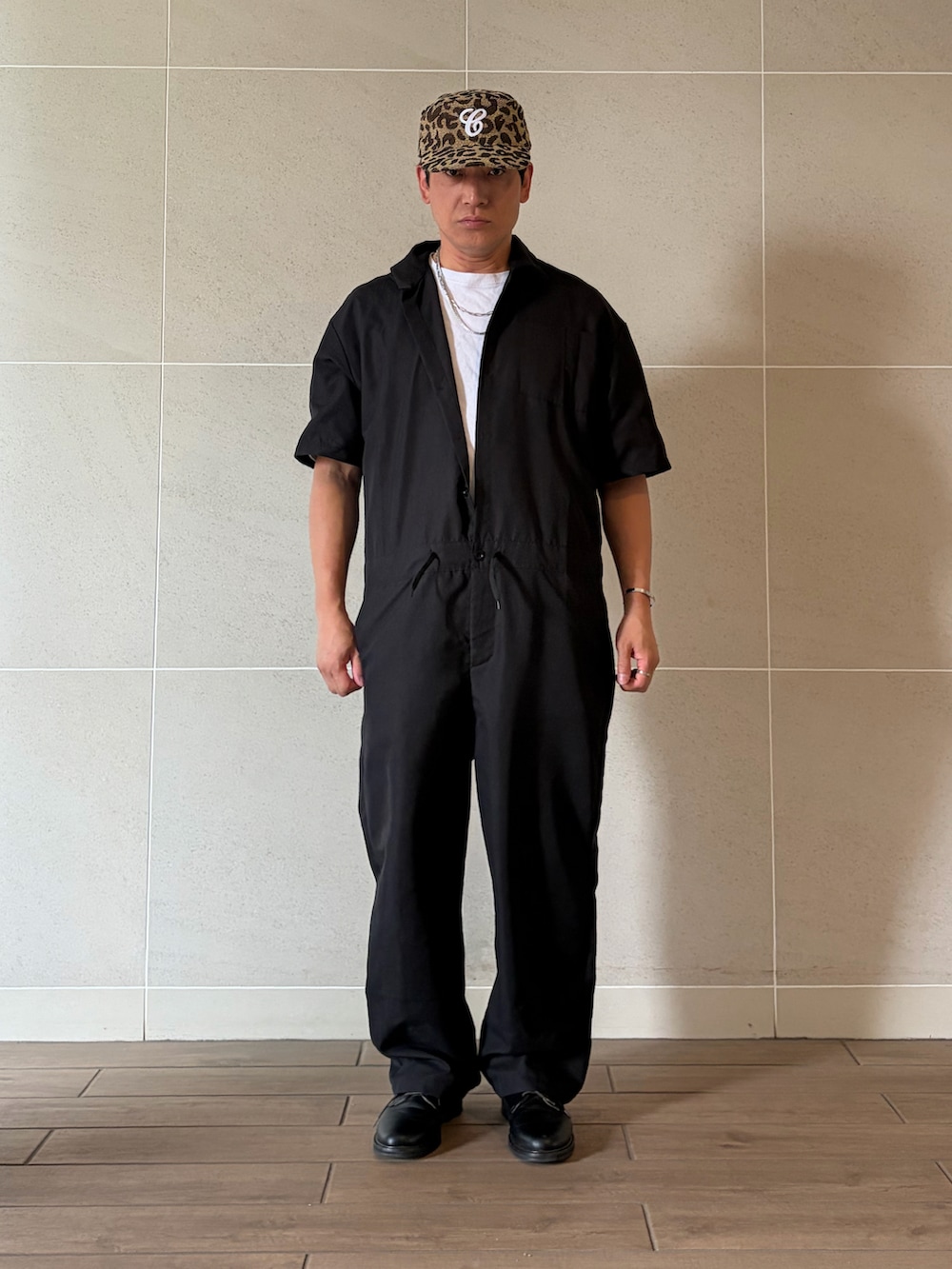 ブラック系のつなぎ/オールインワン、ブラック系のドレスシューズ、その他のキャップを着用したメンズの夏コーディネートの2枚目の写真