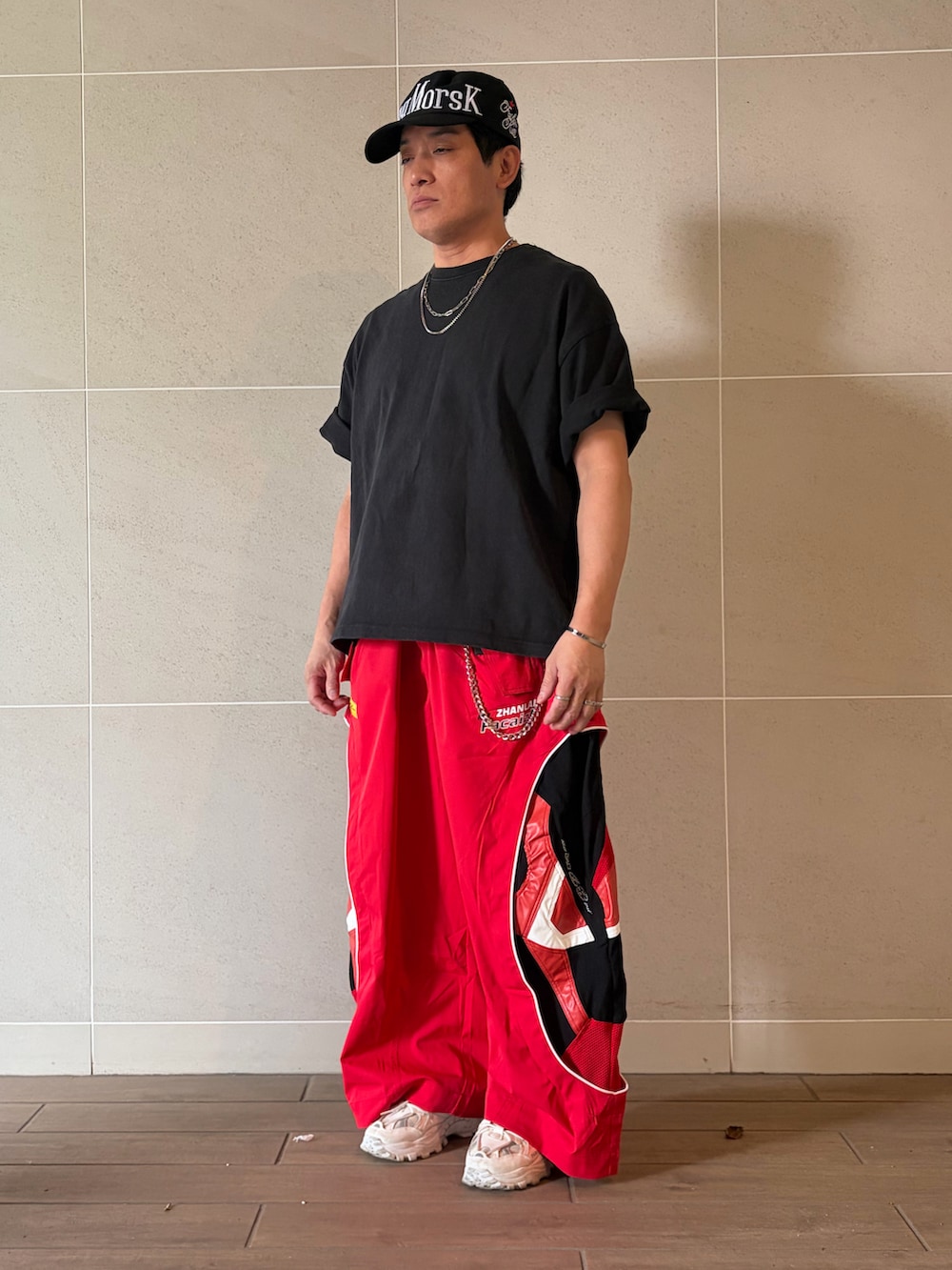 ブラック系のTシャツ/カットソー、ホワイト系のスニーカー、レッド系のその他パンツを着用したメンズの夏コーディネートの2枚目の写真