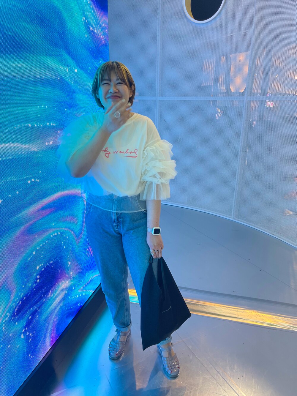 ブラック系のハンドバッグ、その他のサンダル、その他のトップスを着用したレディースの夏コーディネートの2枚目の写真