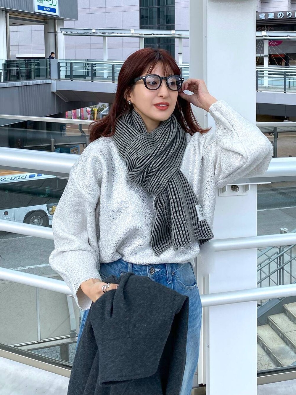 ブルー系のデニムパンツ、グレー系のステンカラーコート、ホワイト系のニット/セーターを着用したレディースの冬コーディネートの5枚目の写真