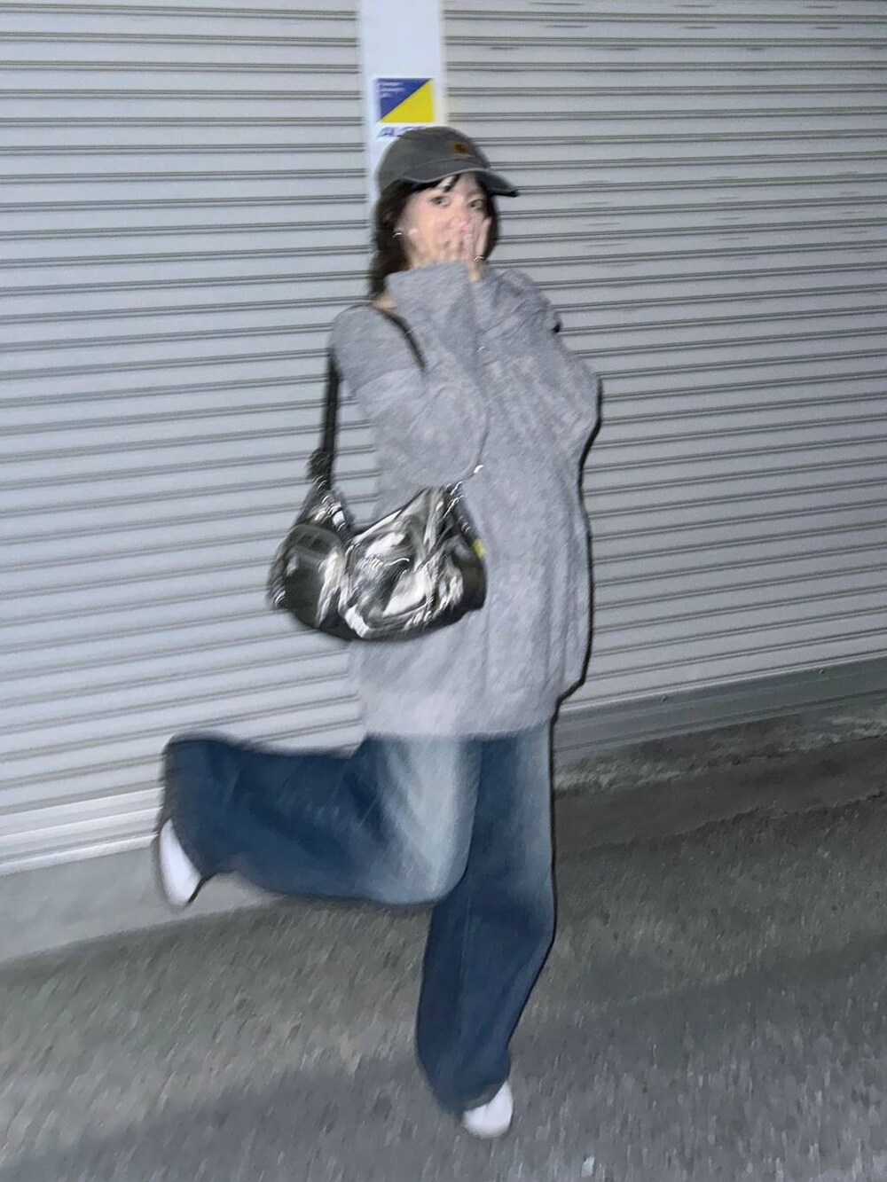 シルバー系のショルダーバッグ、ブルー系のデニムパンツ、グレー系のTシャツ/カットソーを着用したレディースの秋コーディネートの5枚目の写真