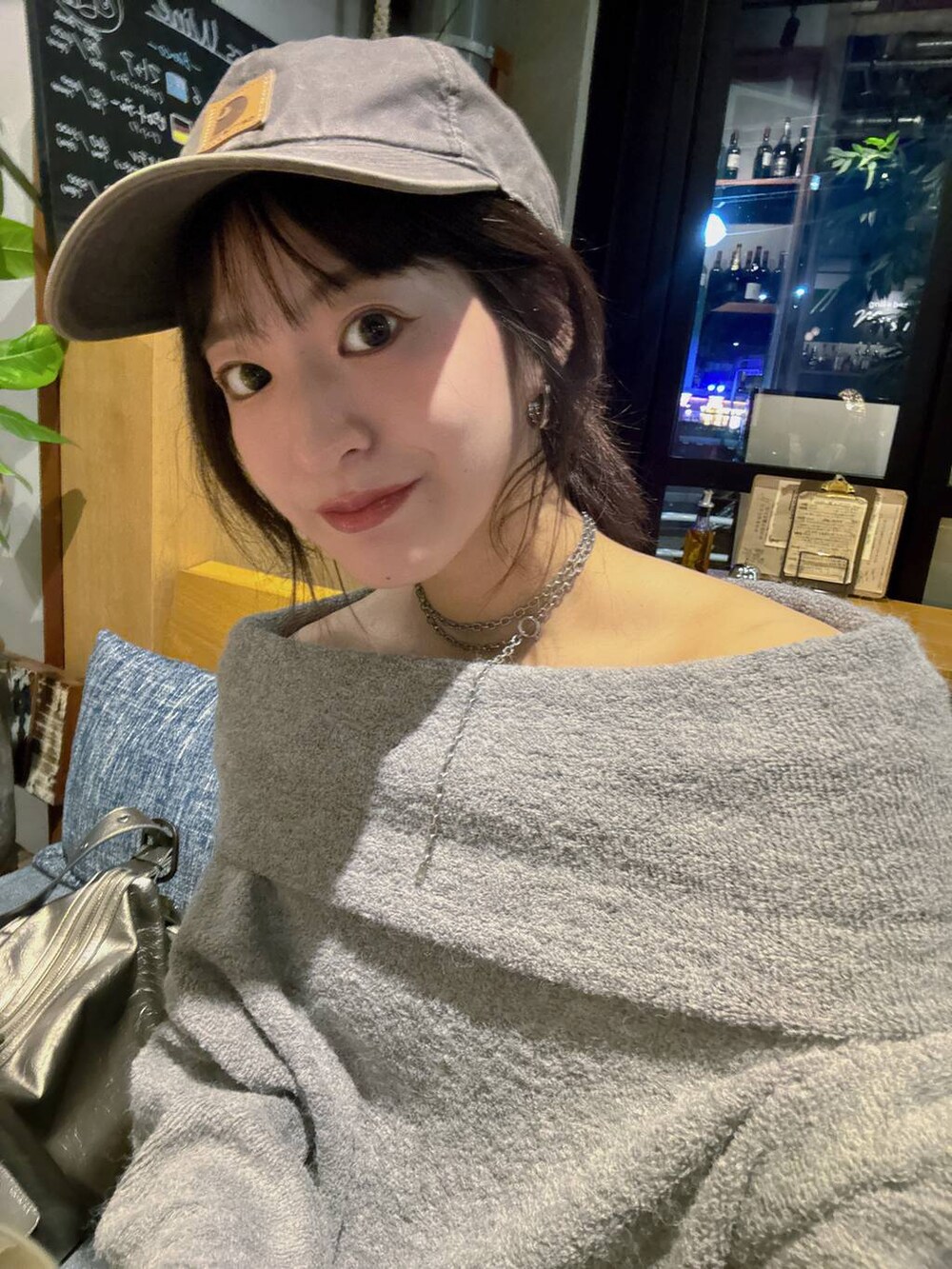 シルバー系のショルダーバッグ、ブルー系のデニムパンツ、グレー系のTシャツ/カットソーを着用したレディースの秋コーディネートの9枚目の写真