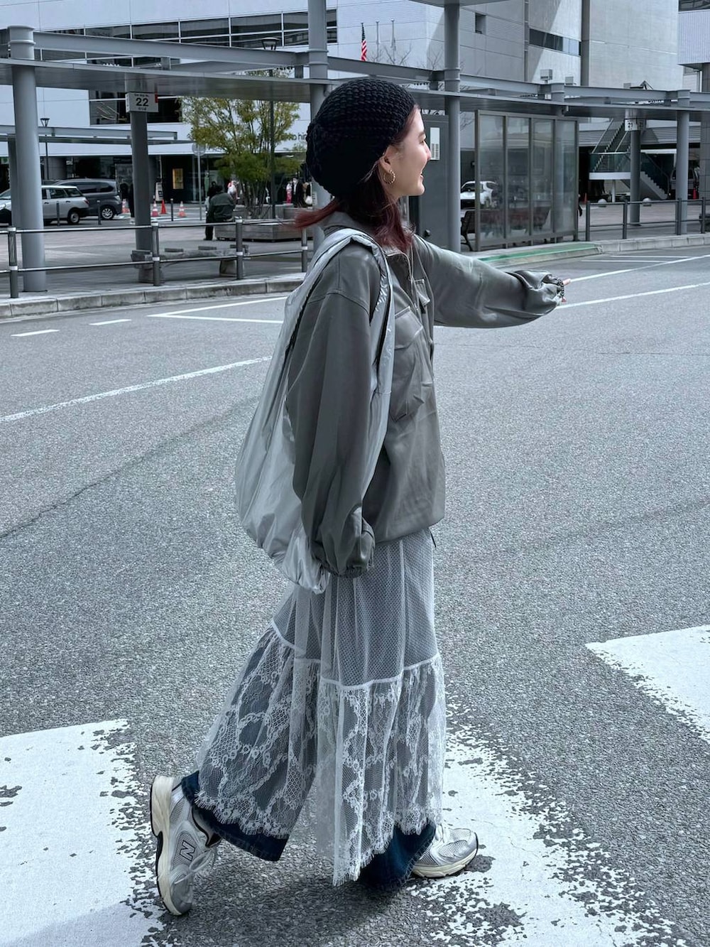 グリーン系のシャツ/ブラウス、ブルー系のデニムパンツ、グレー系のスカートを着用したレディースの春コーディネートの4枚目の写真