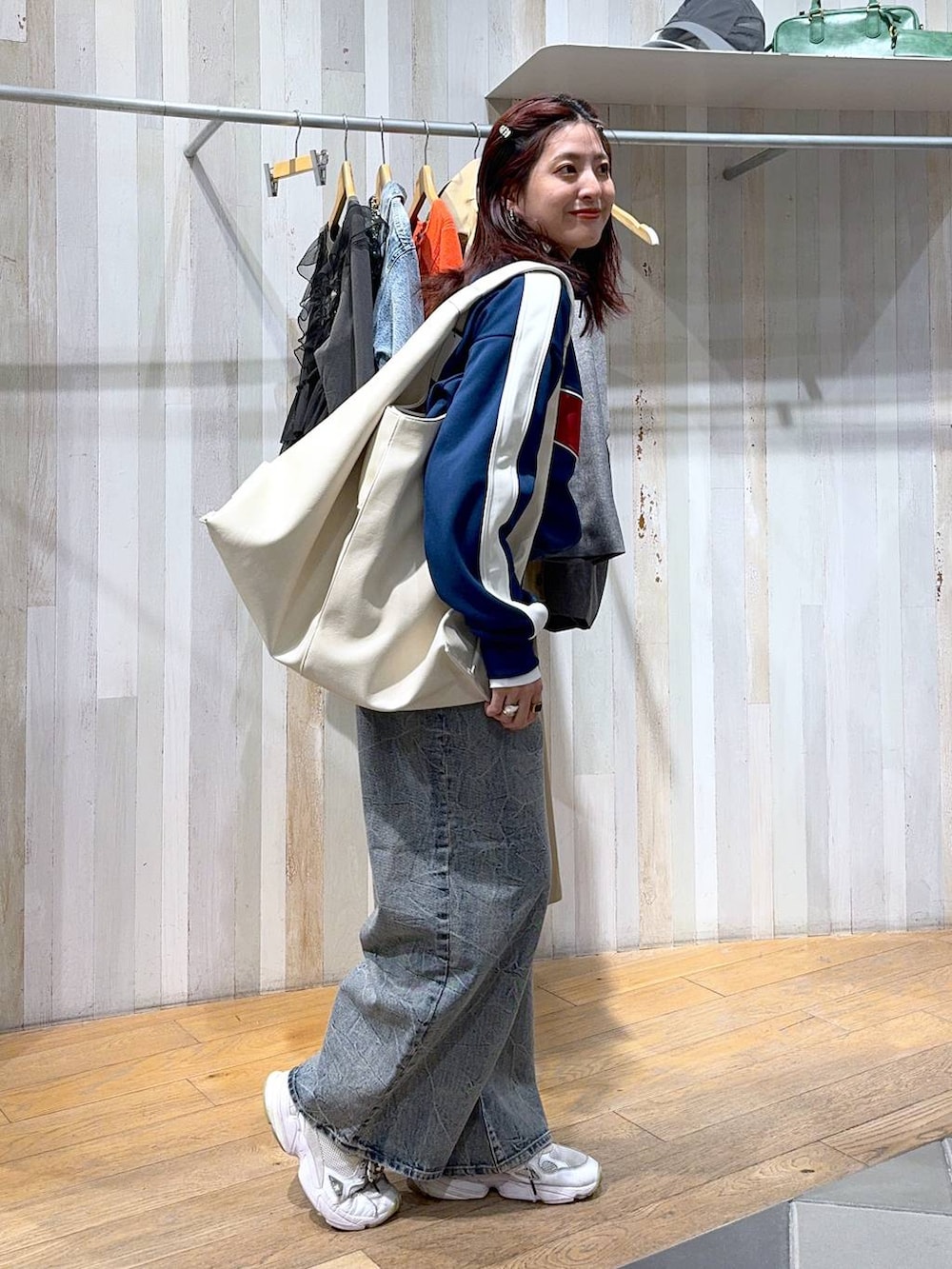 ブルー系のジャージ、ブルー系のデニムパンツ、ホワイト系のトートバッグを着用したレディースの冬コーディネートの3枚目の写真