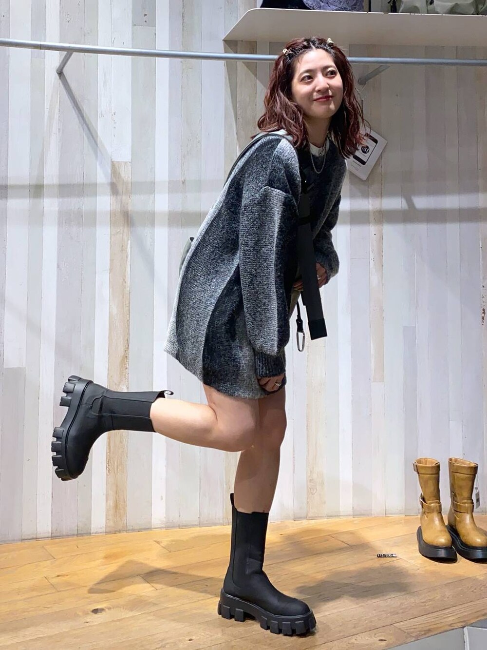 グリーン系のボディバッグ/ウエストポーチ、ブラック系のブーツ、ブラック系のその他パンツを着用したレディースの秋コーディネートの5枚目の写真