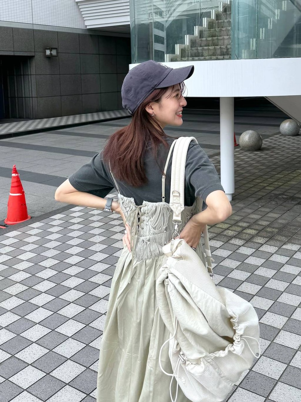 グリーン系のワンピース、ホワイト系のバックパック/リュック、グレー系のTシャツ/カットソーを着用したレディースの夏コーディネートの2枚目の写真
