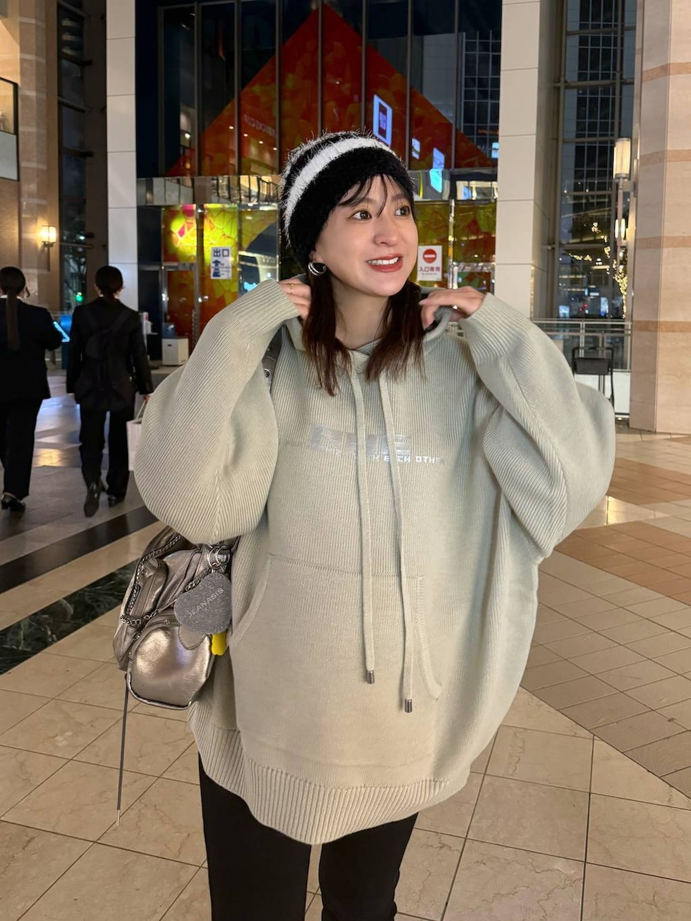 シルバー系のショルダーバッグ、ベージュ系のニット/セーターを着用したレディースの秋コーディネートの3枚目の写真