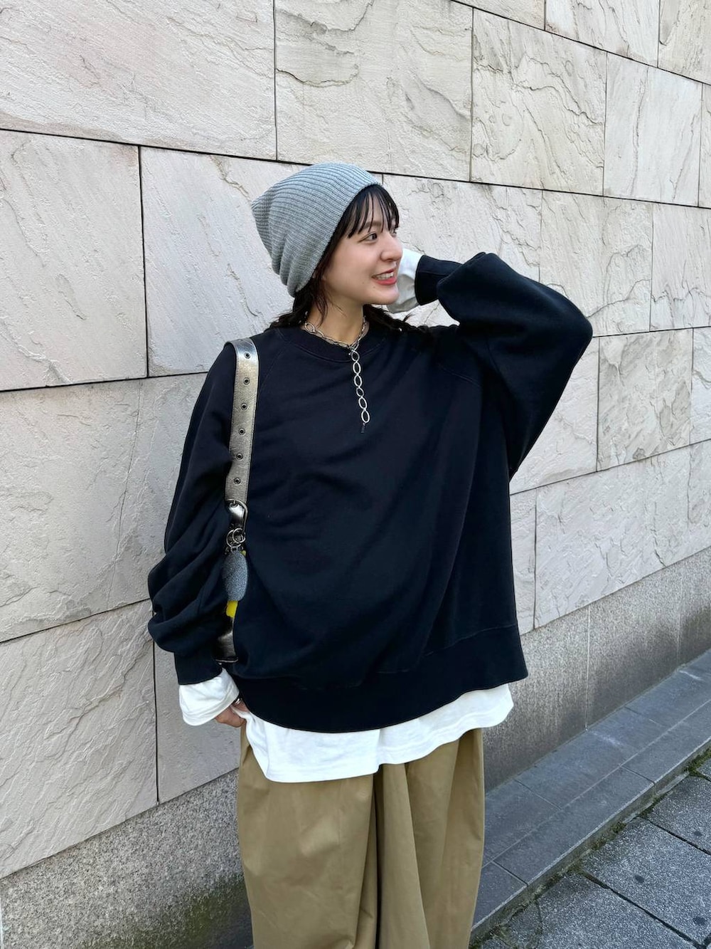 シルバー系のショルダーバッグ、ベージュ系のチノパンツ、ホワイト系のTシャツ/カットソーを着用したレディースの夏コーディネートの3枚目の写真