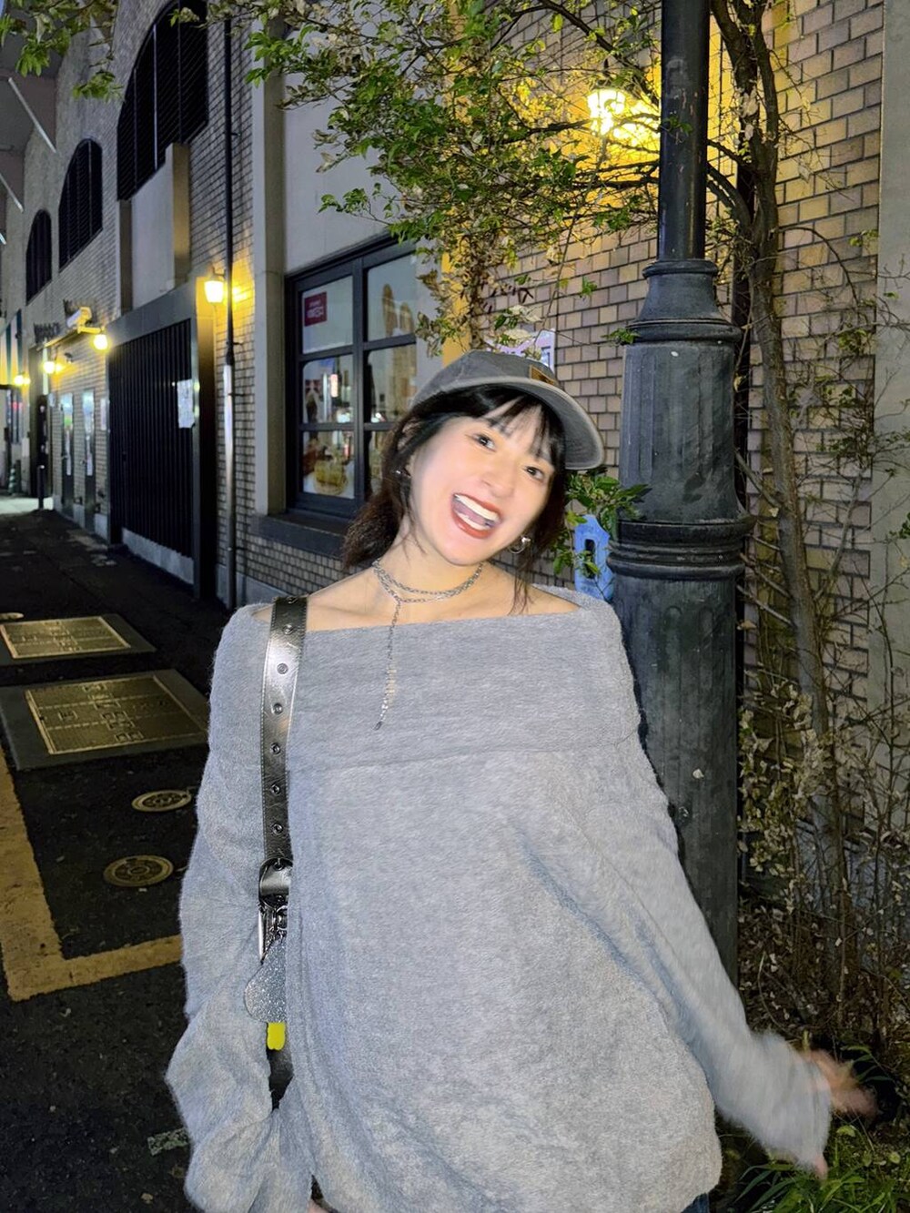 シルバー系のショルダーバッグ、ブルー系のデニムパンツ、グレー系のTシャツ/カットソーを着用したレディースの秋コーディネートの7枚目の写真