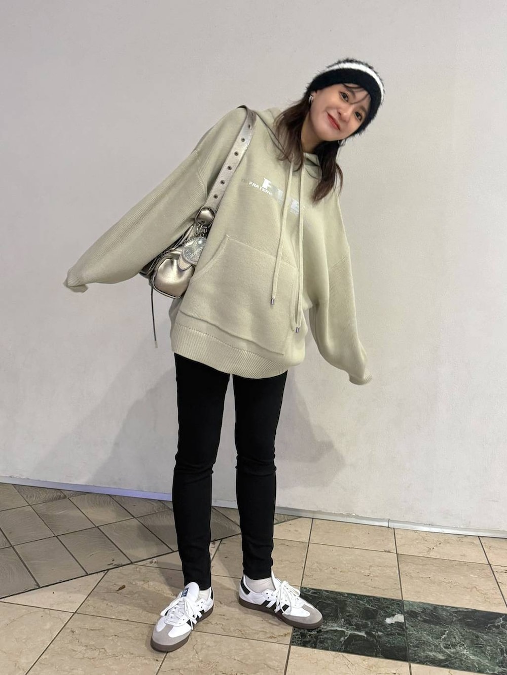 シルバー系のショルダーバッグ、ベージュ系のニット/セーターを着用したレディースの秋コーディネートの2枚目の写真