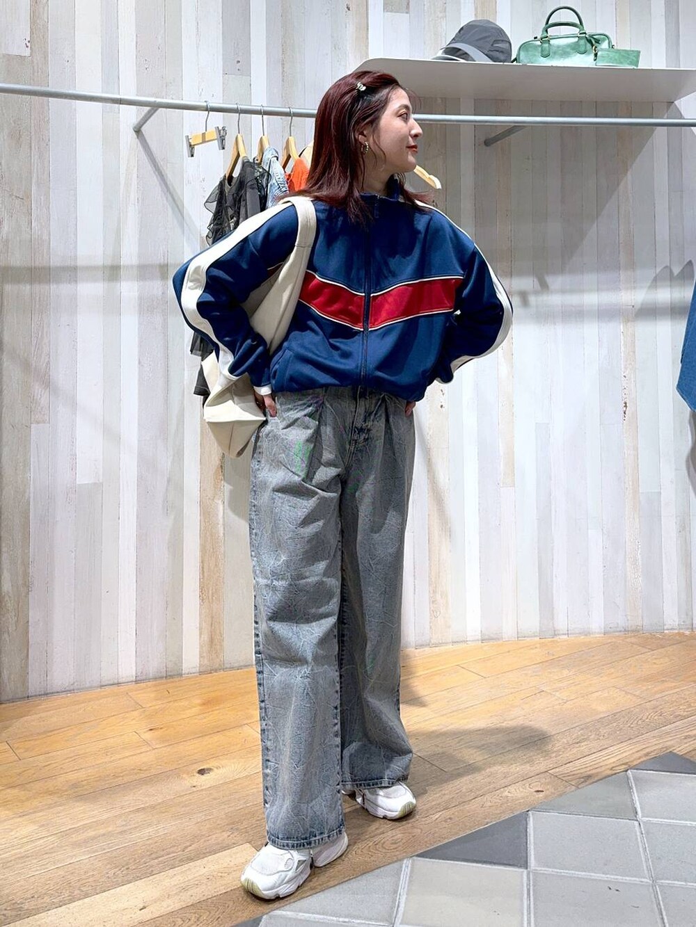 ブルー系のジャージ、ブルー系のデニムパンツ、ホワイト系のトートバッグを着用したレディースの冬コーディネートの4枚目の写真