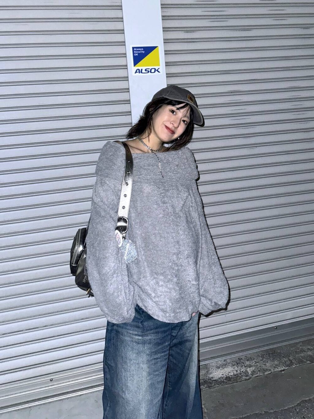 シルバー系のショルダーバッグ、ブルー系のデニムパンツ、グレー系のTシャツ/カットソーを着用したレディースの秋コーディネートの6枚目の写真