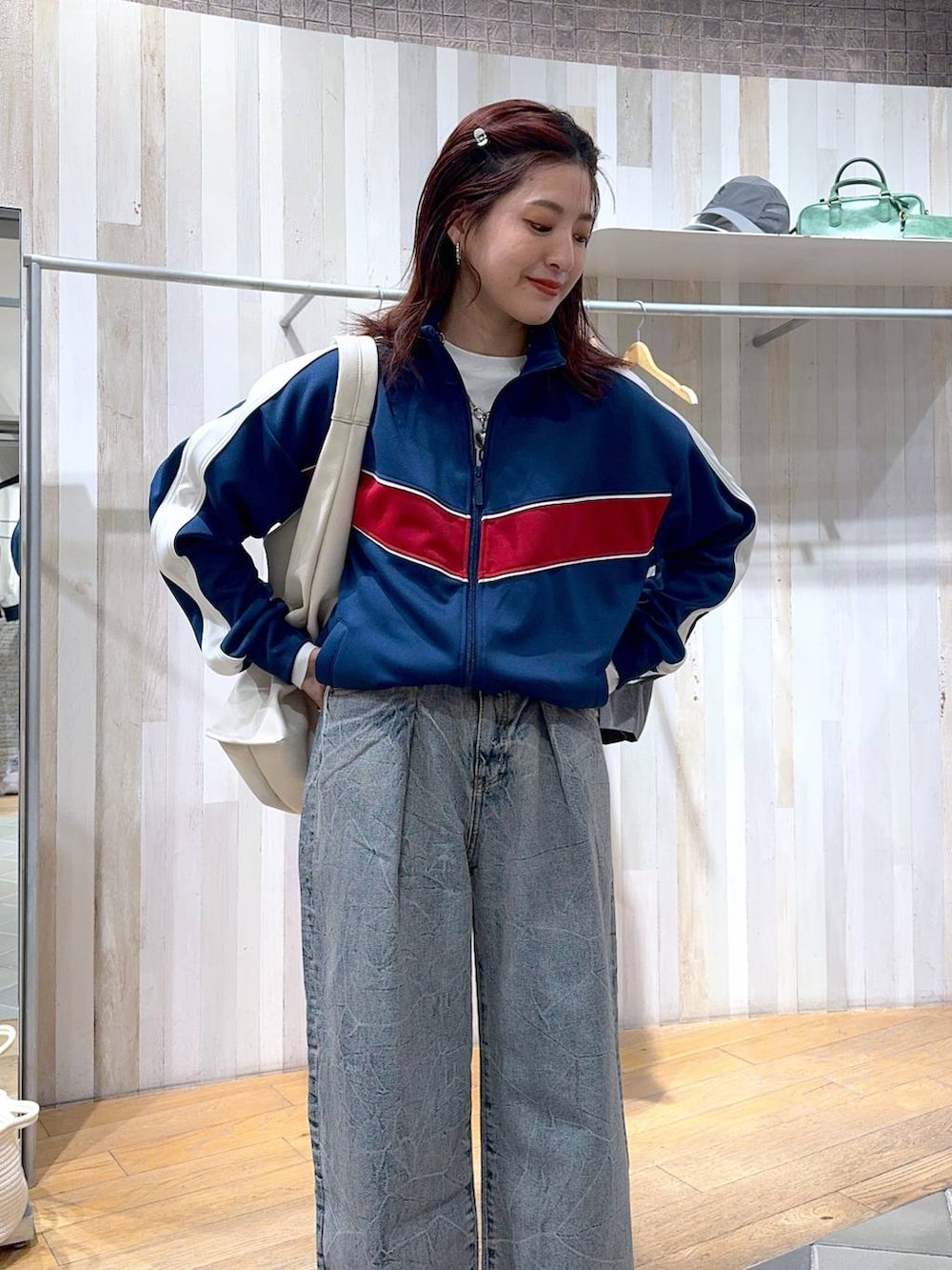 ブルー系のジャージ、ブルー系のデニムパンツ、ホワイト系のトートバッグを着用したレディースの冬コーディネートの2枚目の写真