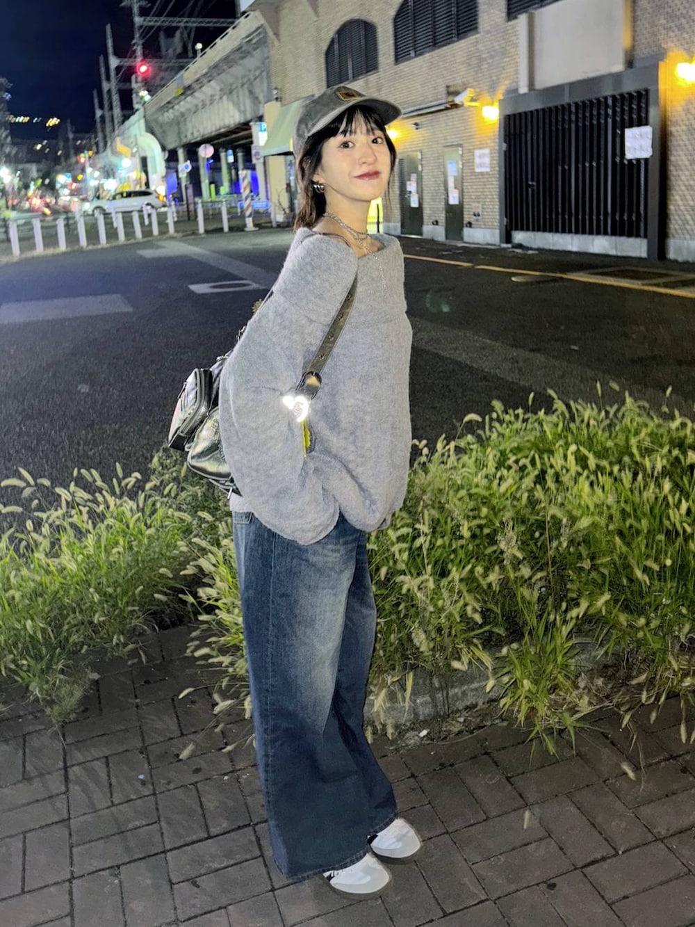 シルバー系のショルダーバッグ、ブルー系のデニムパンツ、グレー系のTシャツ/カットソーを着用したレディースの秋コーディネートの4枚目の写真