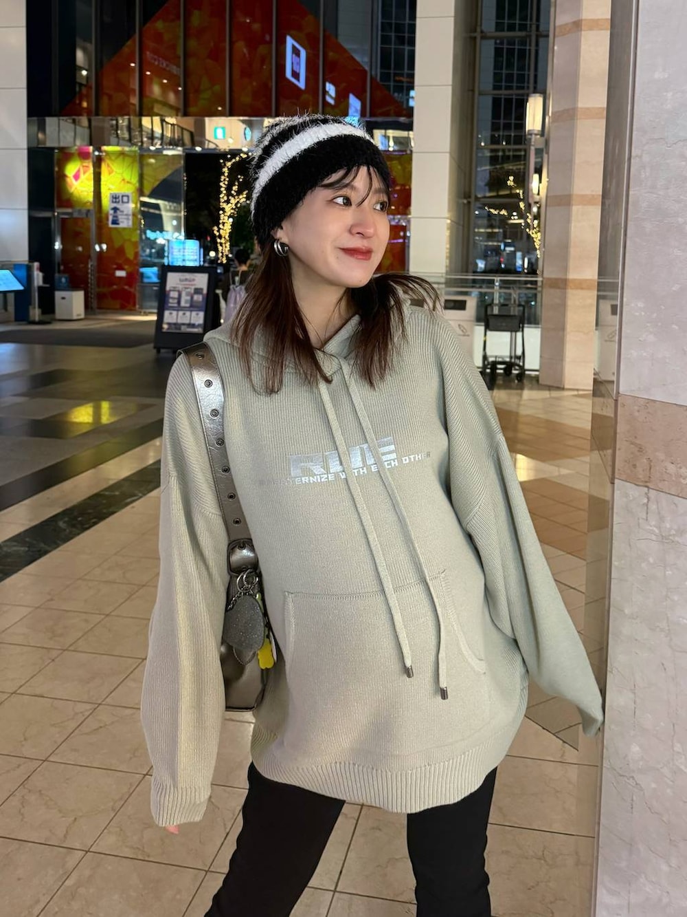 シルバー系のショルダーバッグ、ベージュ系のニット/セーターを着用したレディースの秋コーディネートの6枚目の写真