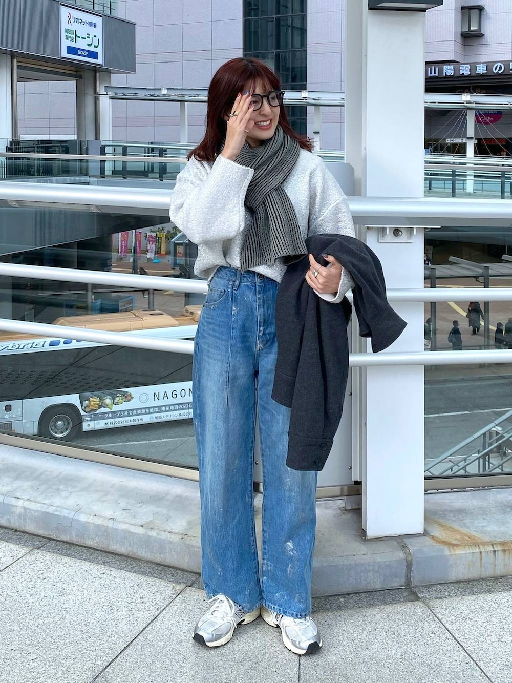 ブルー系のデニムパンツ、グレー系のステンカラーコート、ホワイト系のニット/セーターを着用したレディースの冬コーディネートの4枚目の写真