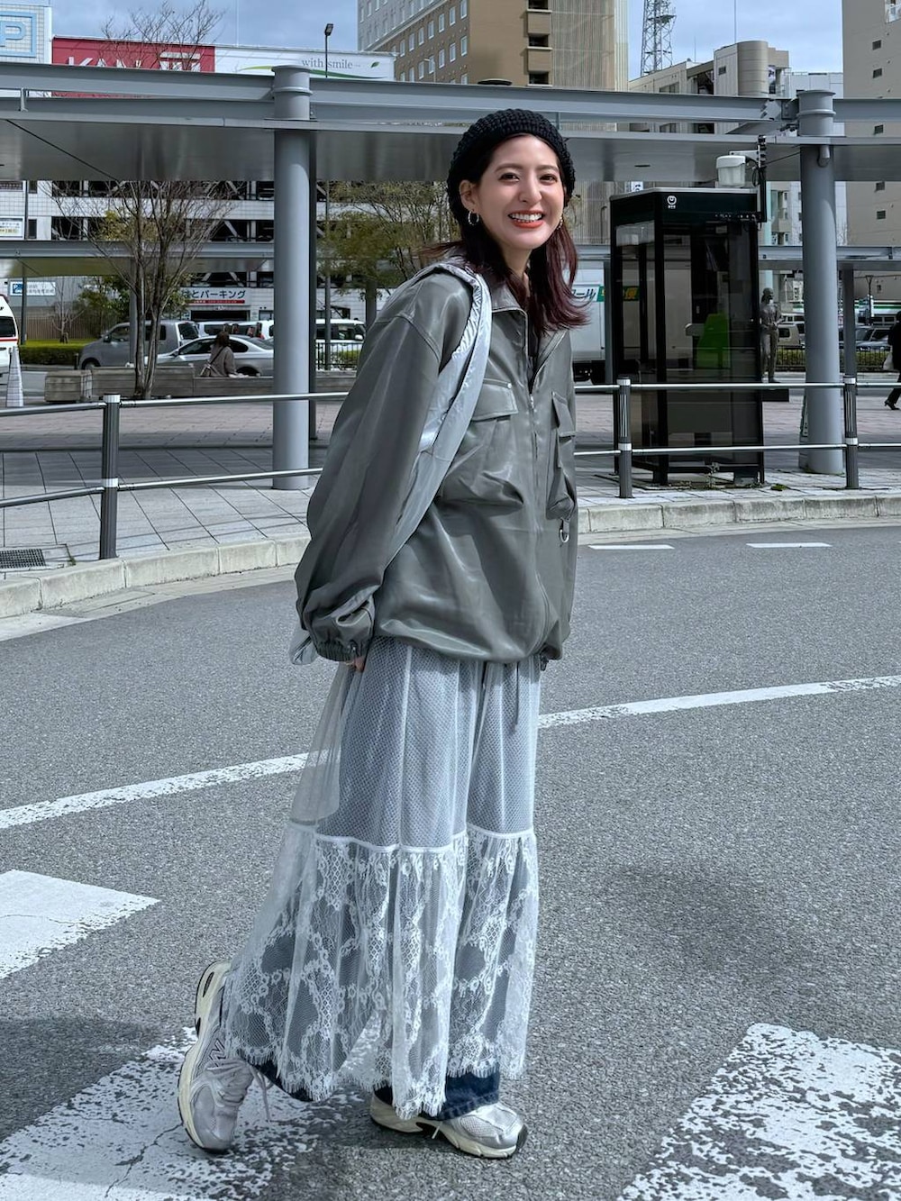 グリーン系のシャツ/ブラウス、ブルー系のデニムパンツ、グレー系のスカートを着用したレディースの春コーディネートの3枚目の写真