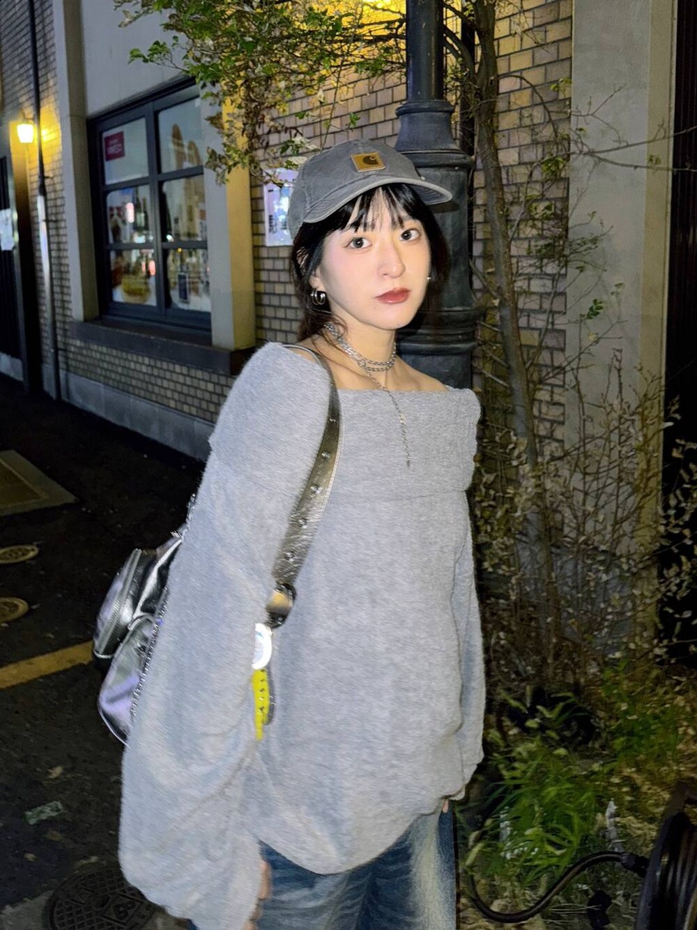 シルバー系のショルダーバッグ、ブルー系のデニムパンツ、グレー系のTシャツ/カットソーを着用したレディースの秋コーディネートの8枚目の写真