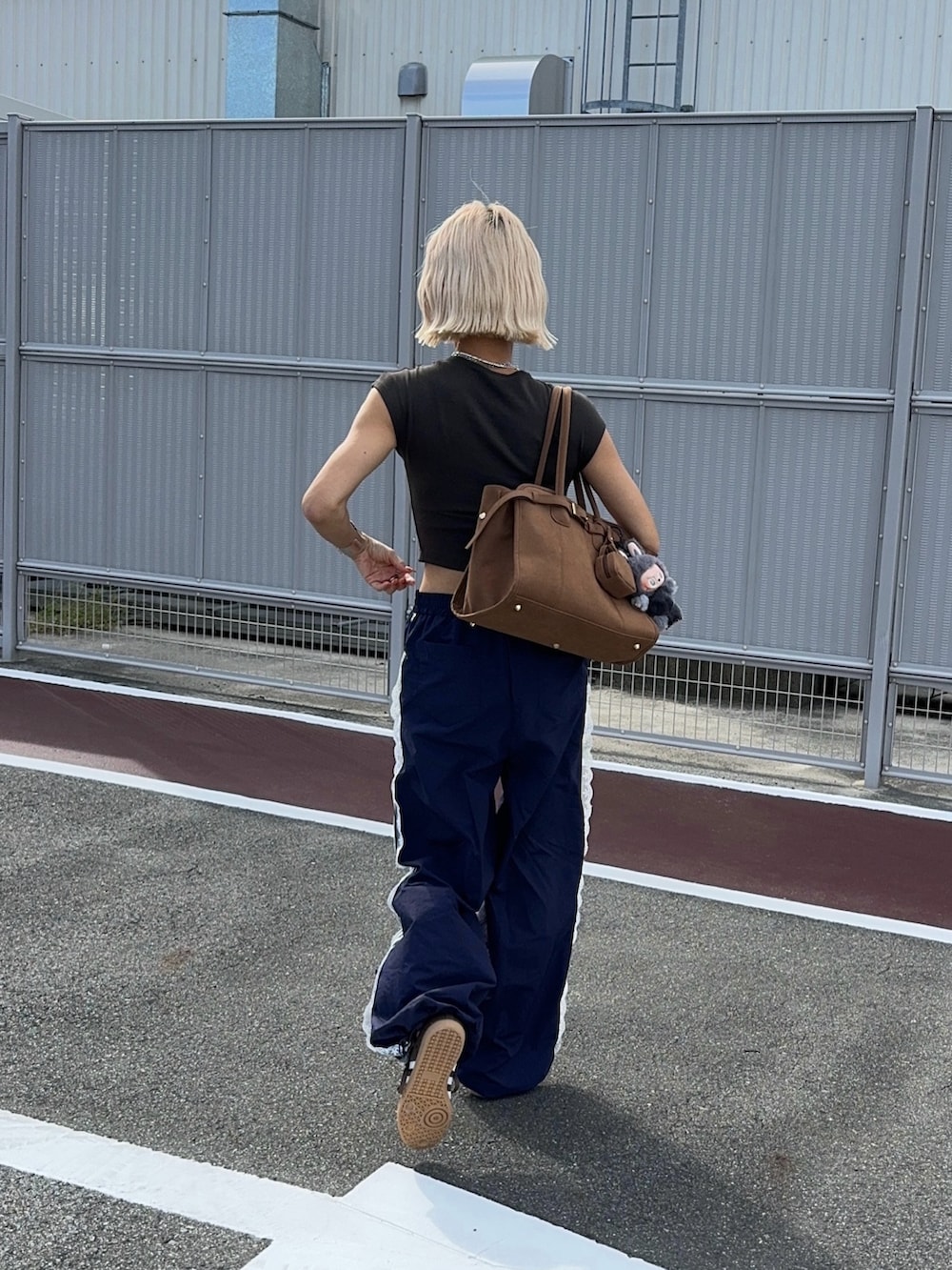 ブルー系のその他パンツ、ブラウン系のスニーカー、ブラウン系のボストンバッグを着用したレディースの秋コーディネートの3枚目の写真