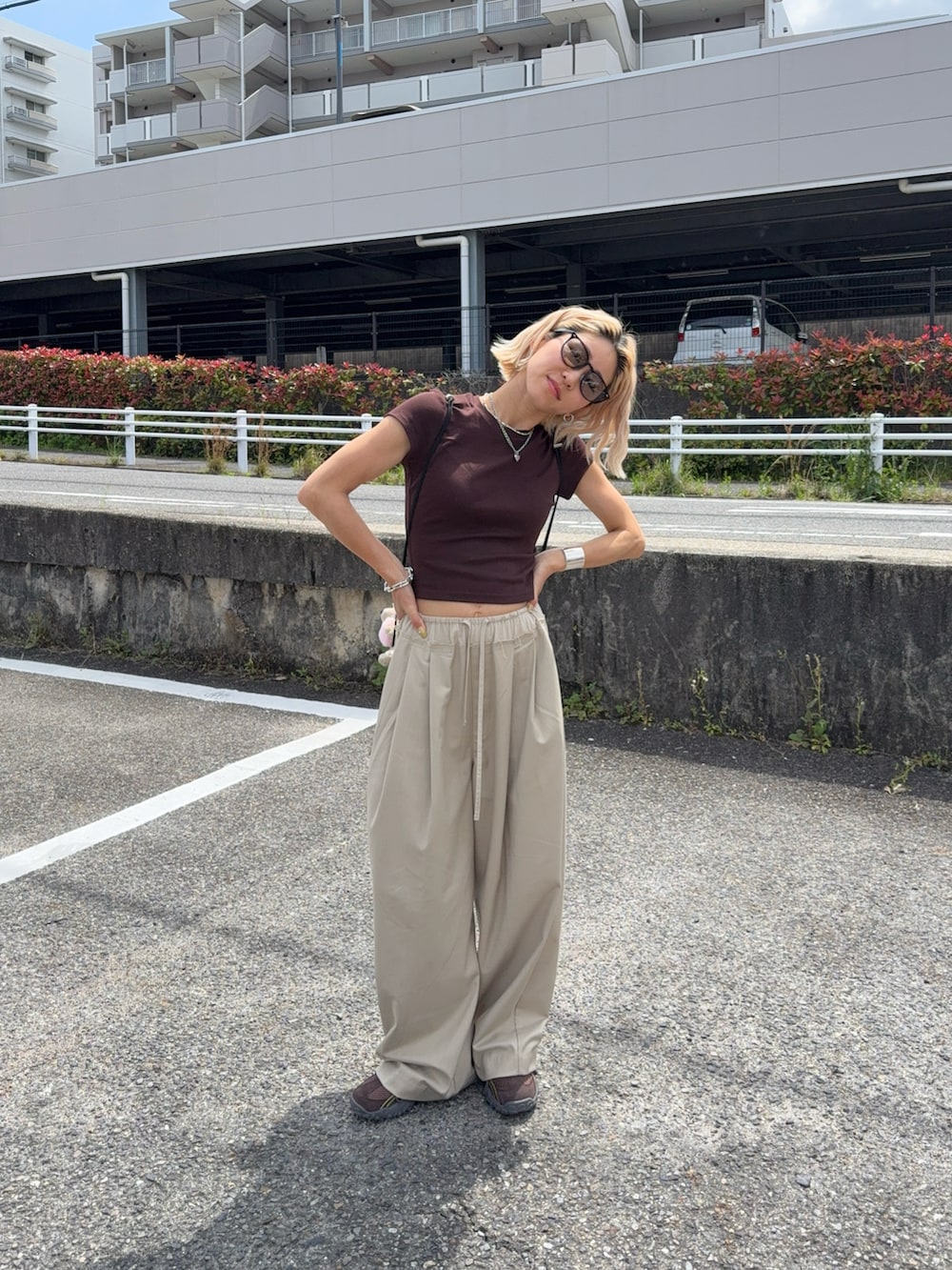 ブラウン系のバックパック/リュック、ブラック系のTシャツ/カットソー、ブラウン系のスニーカーを着用したレディースの春コーディネートの2枚目の写真