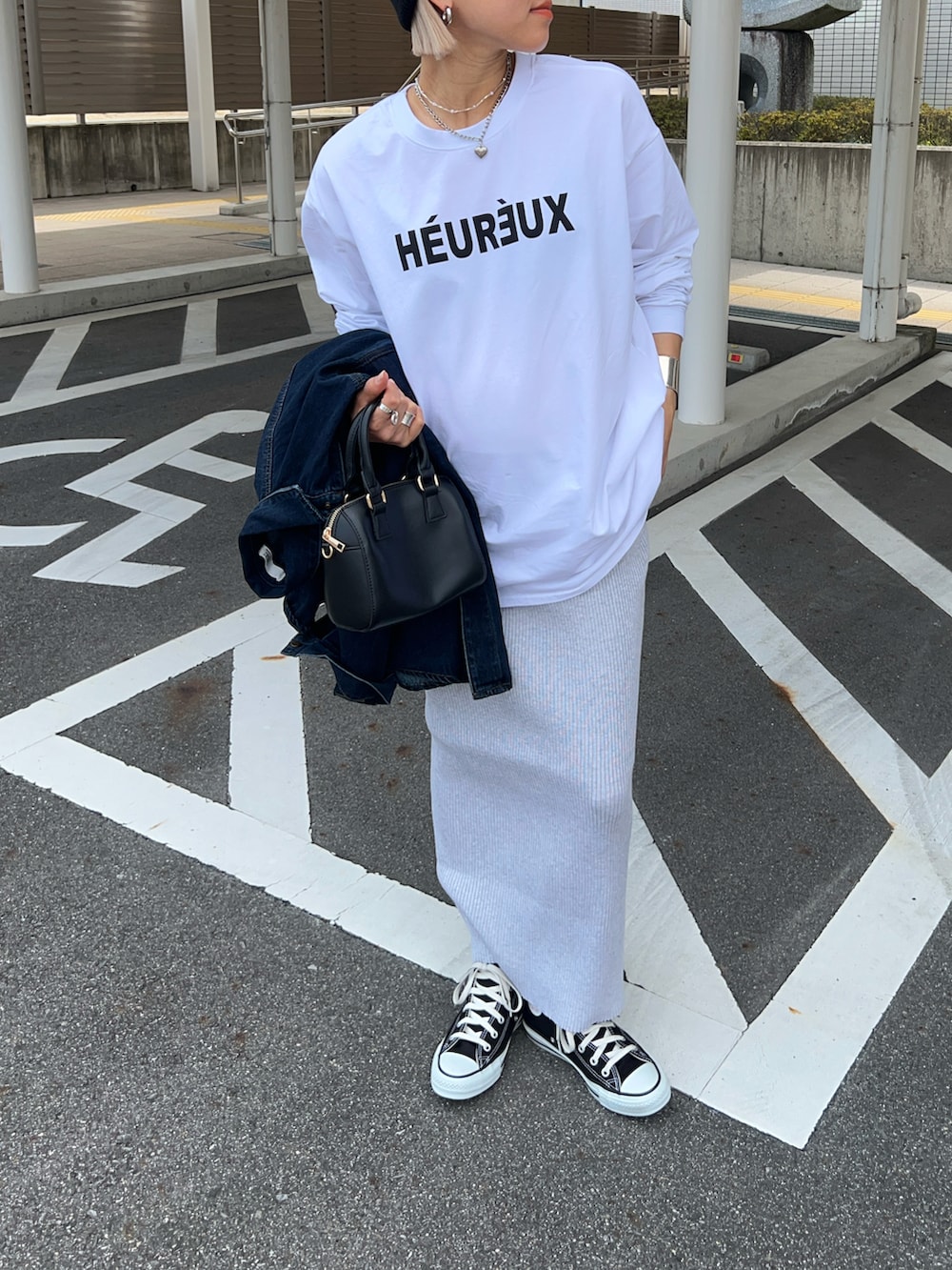 ホワイト系のTシャツ/カットソー、ブラック系のボストンバッグ、グレー系のスカートを着用したレディースの春コーディネートの3枚目の写真