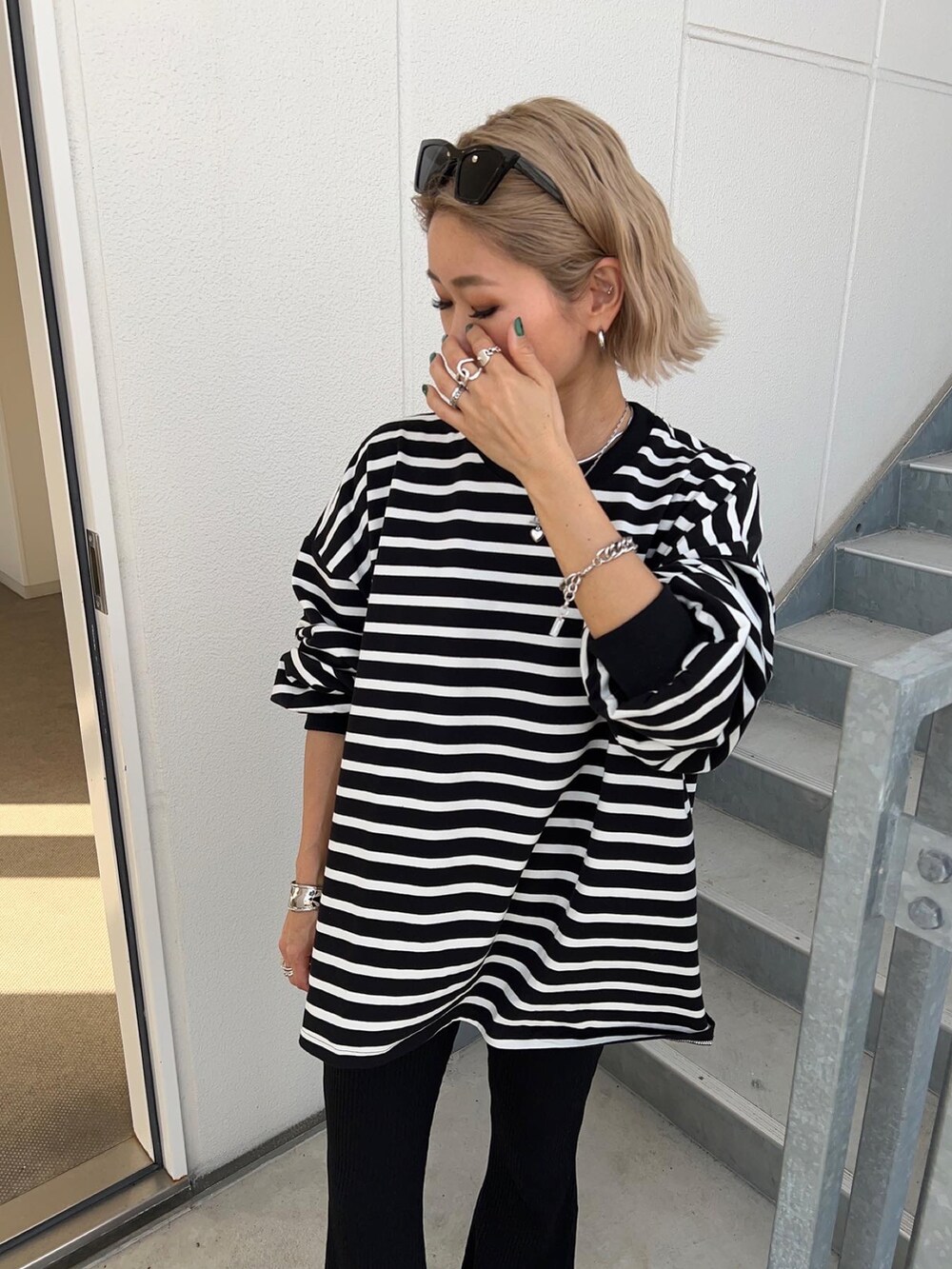 ブラック系のパンツ、グレー系のスニーカー、グリーン系のショルダーバッグを着用したレディースの春コーディネートの4枚目の写真