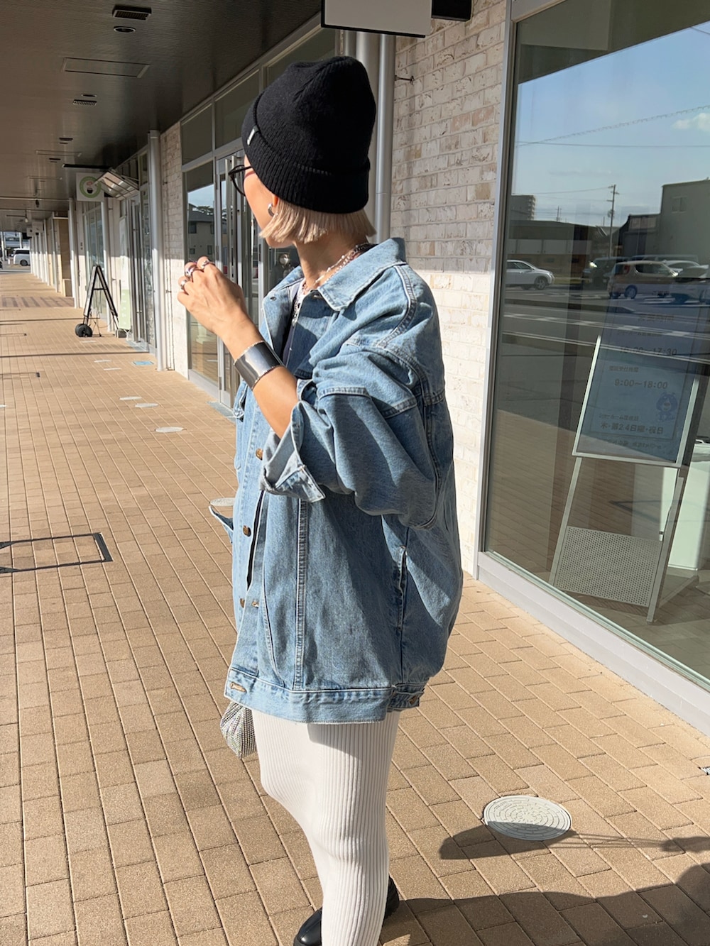 ホワイト系のスカート、ブラック系のブーツ、シルバー系のショルダーバッグを着用したレディースの冬コーディネートの5枚目の写真