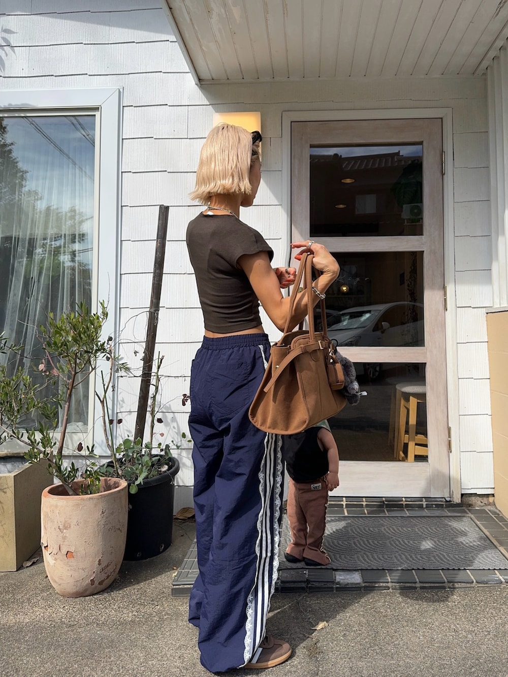 ブルー系のその他パンツ、ブラウン系のスニーカー、ブラウン系のボストンバッグを着用したレディースの秋コーディネートの2枚目の写真