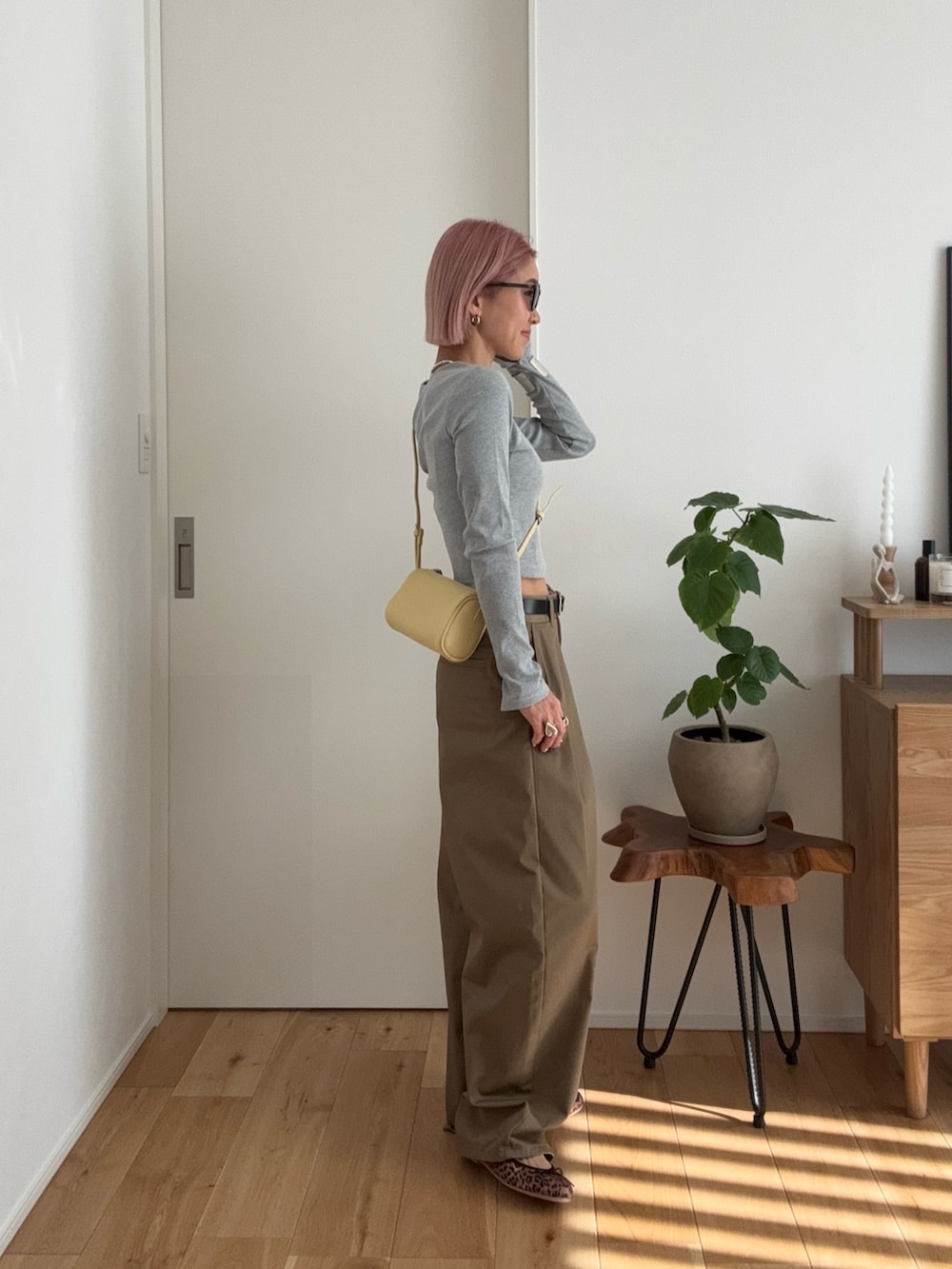 グレー系のTシャツ/カットソー、イエロー系のショルダーバッグ、ベージュ系のチノパンツを着用したレディースの冬コーディネートの2枚目の写真