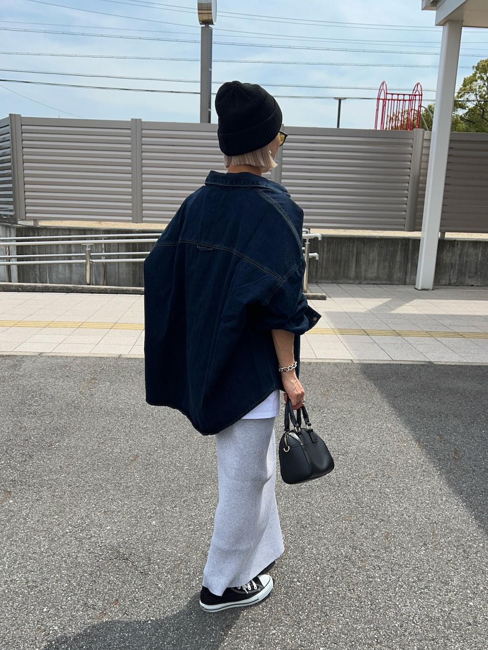 ホワイト系のTシャツ/カットソー、ブラック系のボストンバッグ、グレー系のスカートを着用したレディースの春コーディネートの4枚目の写真