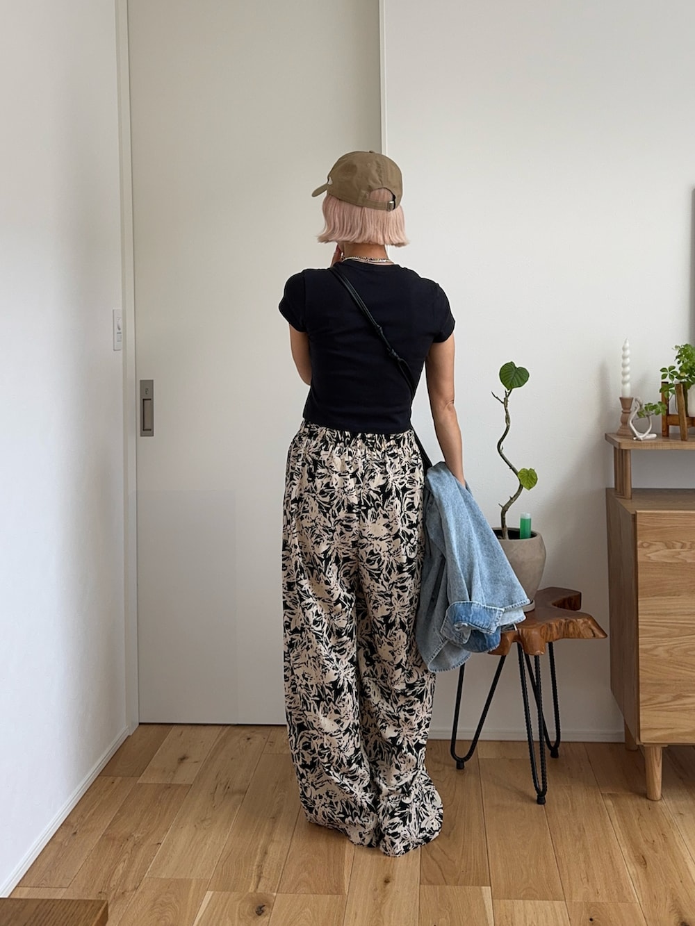 ブラック系のその他パンツ、ブラック系のTシャツ/カットソー、ベージュ系のキャップを着用したレディースの春コーディネートの2枚目の写真