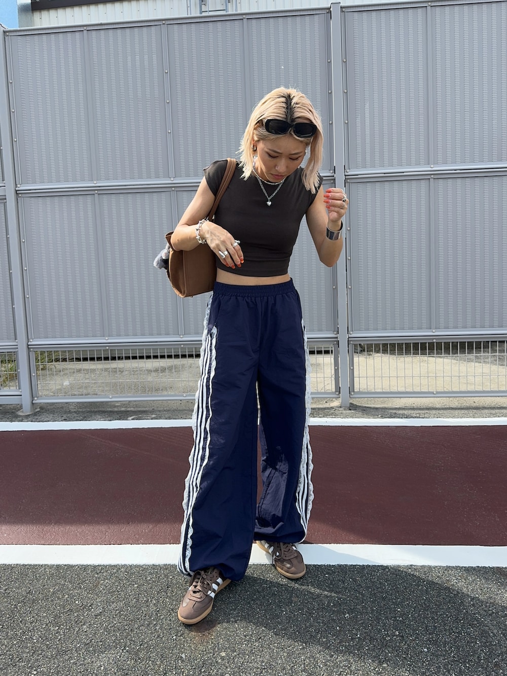 ブルー系のその他パンツ、ブラウン系のスニーカー、ブラウン系のボストンバッグを着用したレディースの秋コーディネートの4枚目の写真