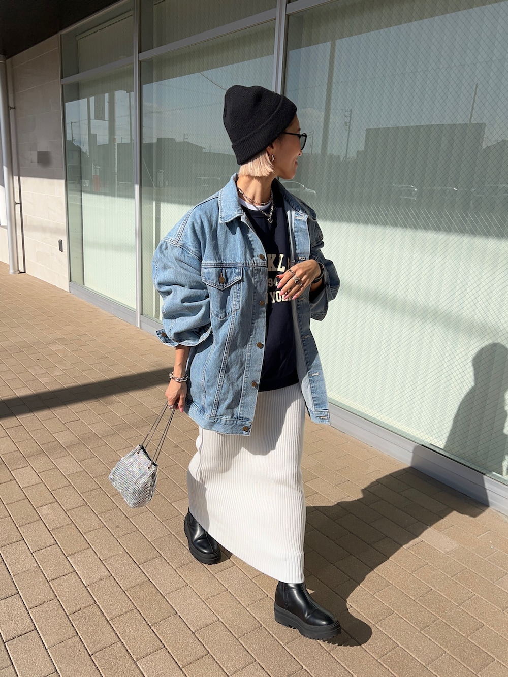 ホワイト系のスカート、ブラック系のブーツ、シルバー系のショルダーバッグを着用したレディースの冬コーディネートの4枚目の写真