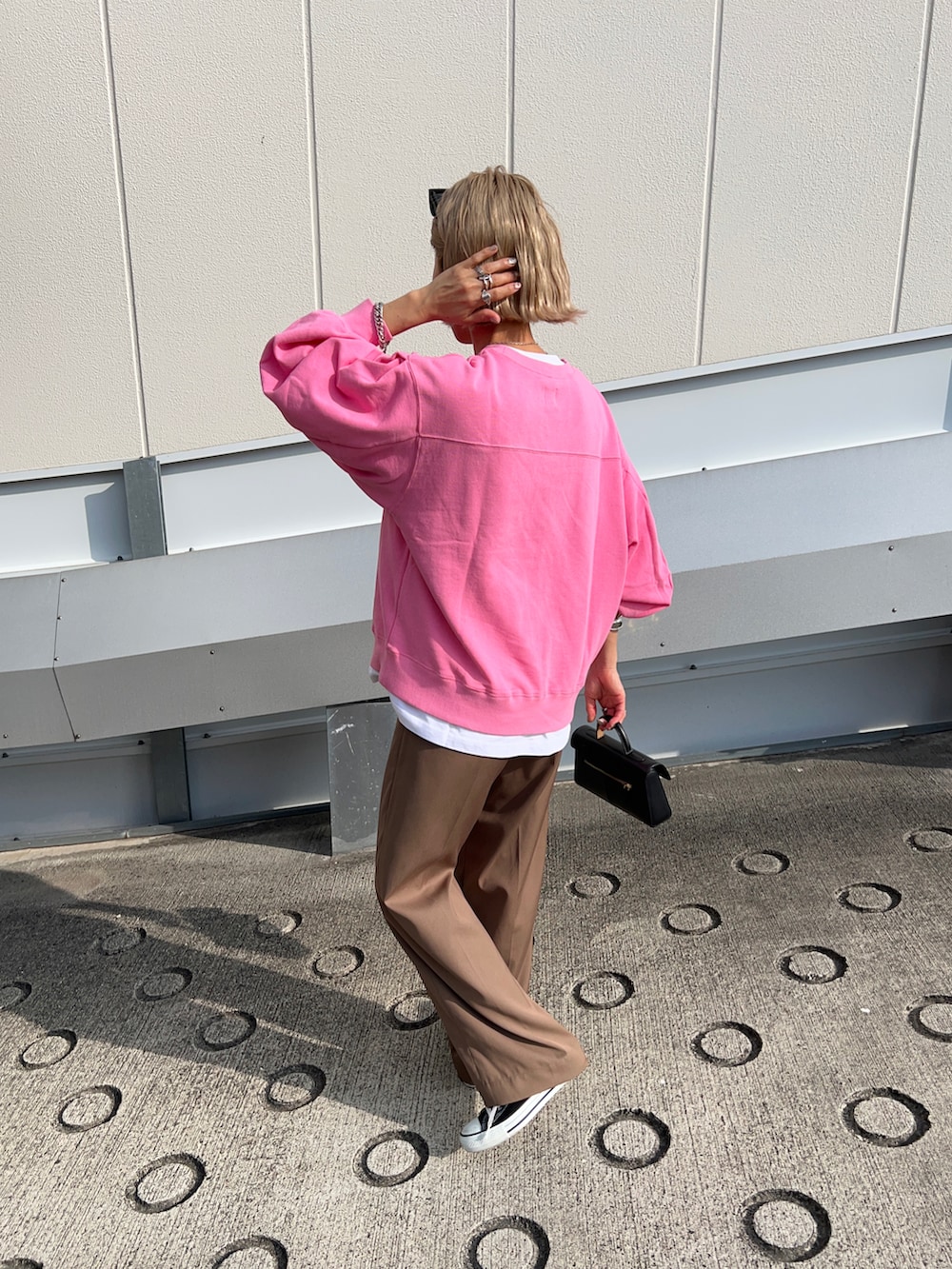 ブラウン系のその他パンツ、ブラック系のショルダーバッグ、ピンク系のスウェットを着用したレディースの春コーディネートの3枚目の写真