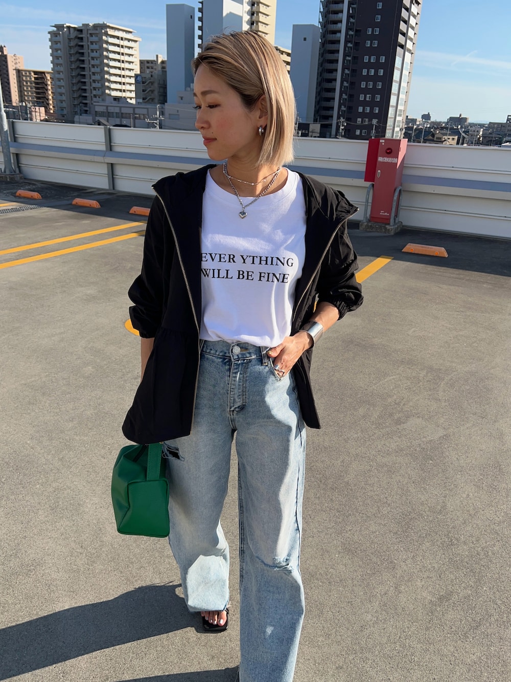 ブルー系のデニムパンツ、ブラック系のサンダル、グリーン系のショルダーバッグを着用したレディースの春コーディネートの4枚目の写真