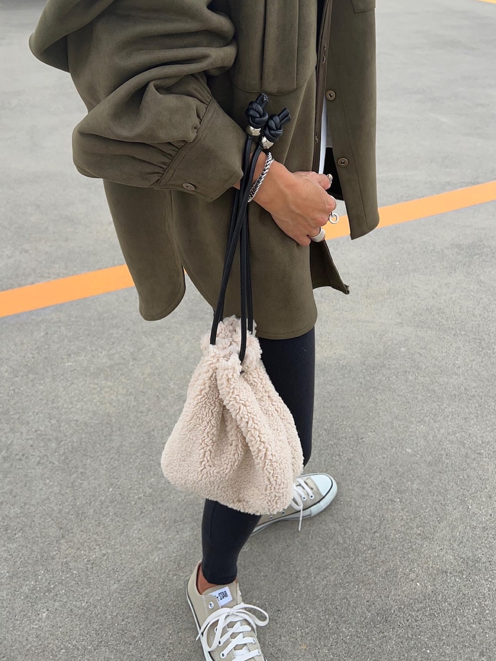 グリーン系のミリタリージャケット、ベージュ系のバッグを着用したレディースの秋コーディネートの4枚目の写真