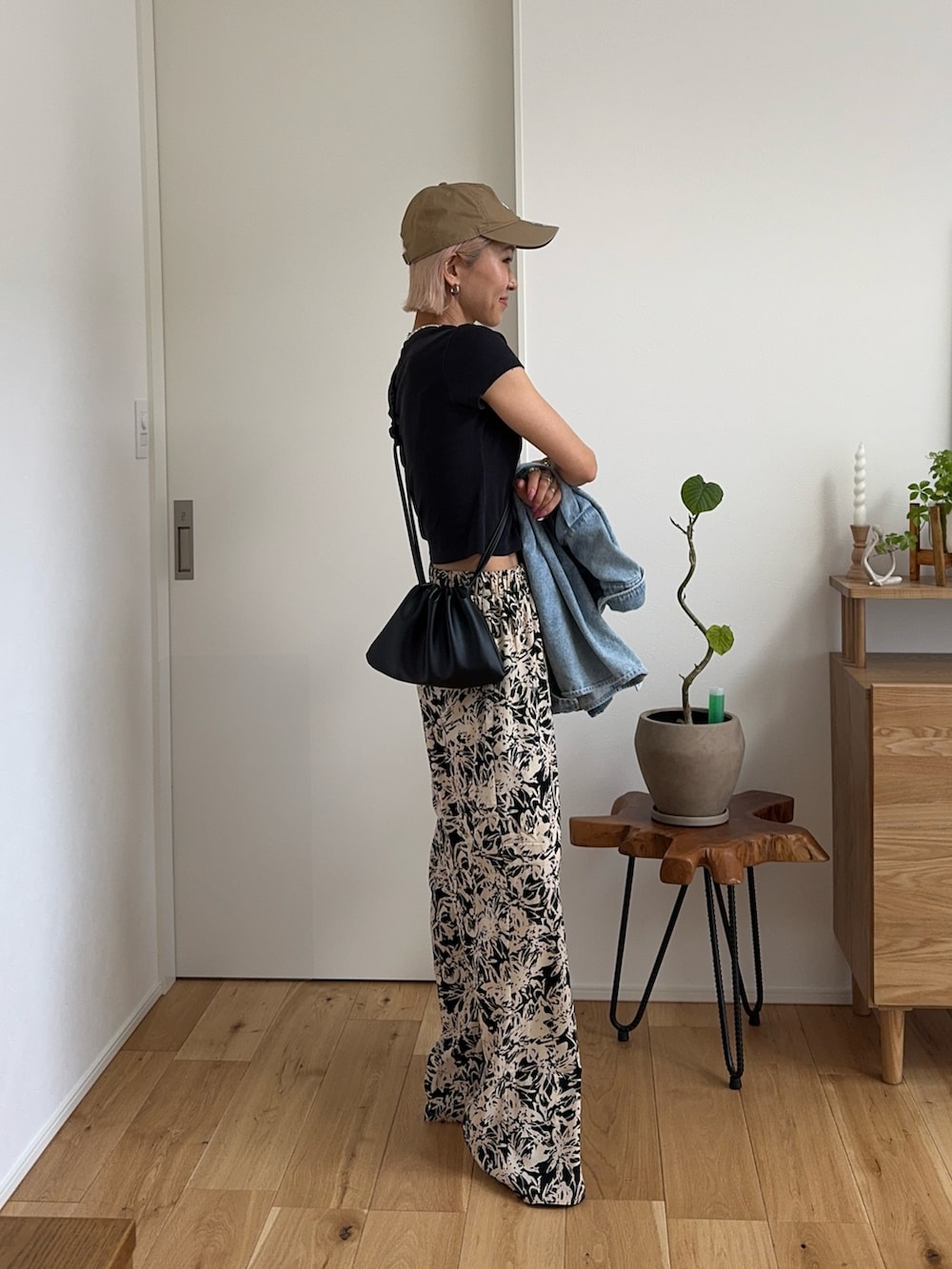 ブラック系のその他パンツ、ブラック系のTシャツ/カットソー、ベージュ系のキャップを着用したレディースの春コーディネートの4枚目の写真