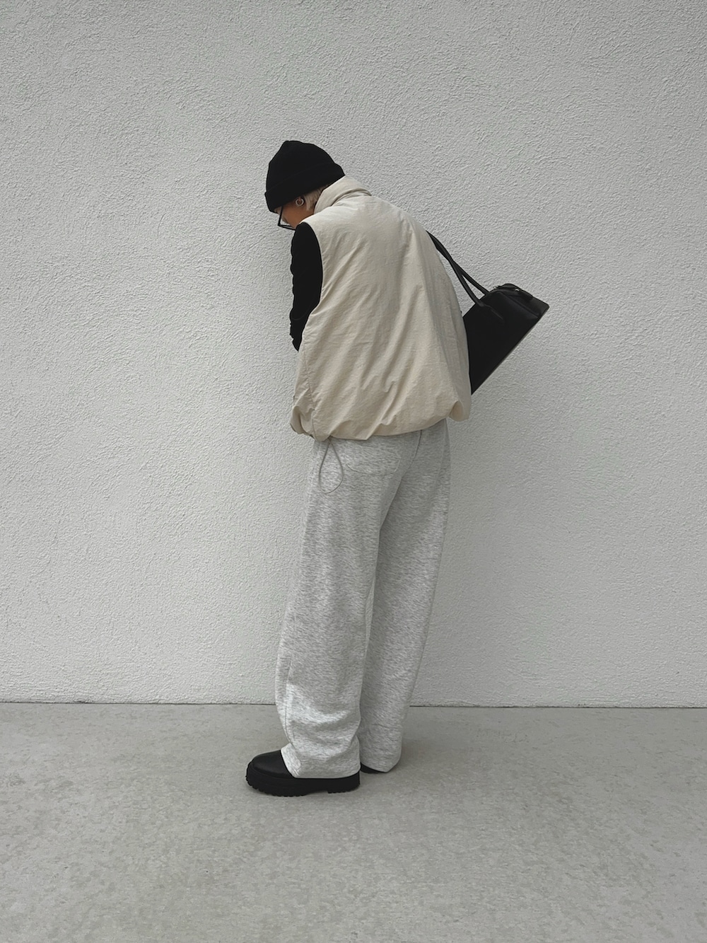 グレー系のその他パンツ、ブラック系のブーツ、ブラック系のTシャツ/カットソーを着用したレディースの秋コーディネートの2枚目の写真