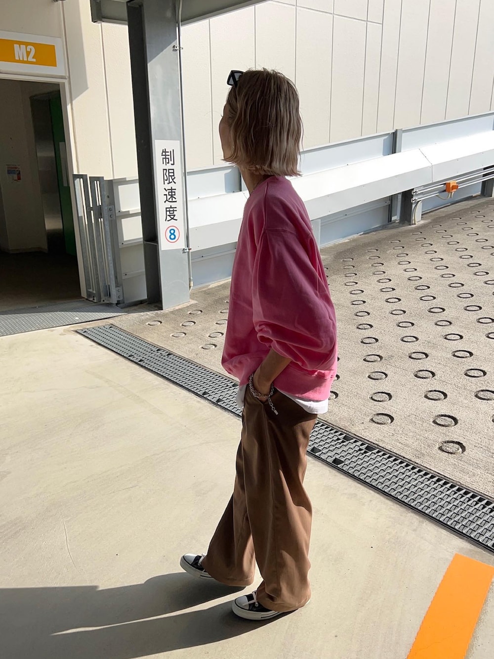 ブラウン系のその他パンツ、ブラック系のショルダーバッグ、ピンク系のスウェットを着用したレディースの春コーディネートの4枚目の写真