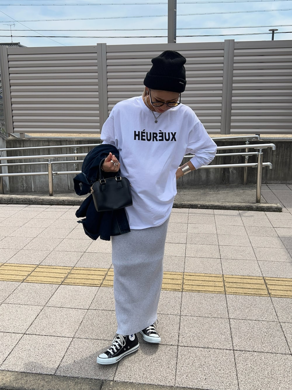 ホワイト系のTシャツ/カットソー、ブラック系のボストンバッグ、グレー系のスカートを着用したレディースの春コーディネートの2枚目の写真