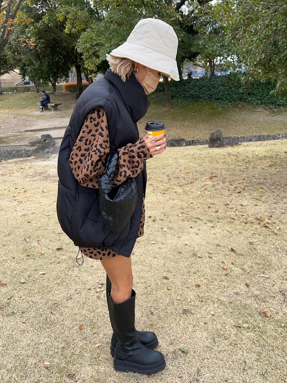 ブラック系のブーツ、ブラック系のハンドバッグ、ブラック系のベストを着用したレディースの冬コーディネートの4枚目の写真