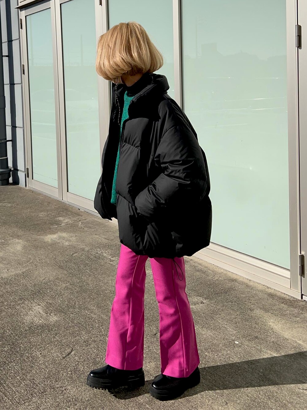 ピンク系のその他パンツ、ブラック系のブーツ、ブラック系のダウンジャケット/コートを着用したレディースの冬コーディネートの5枚目の写真