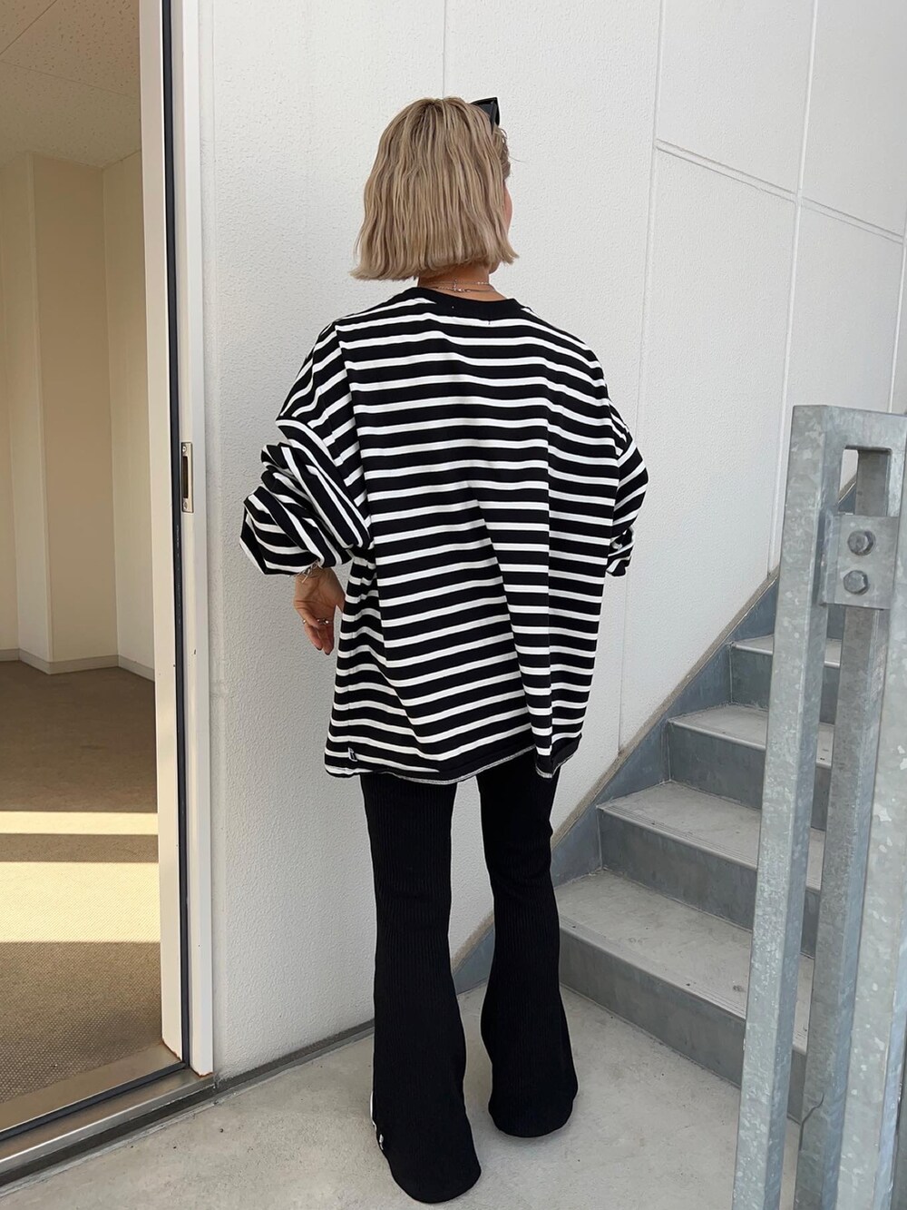 ブラック系のパンツ、グレー系のスニーカー、グリーン系のショルダーバッグを着用したレディースの春コーディネートの5枚目の写真