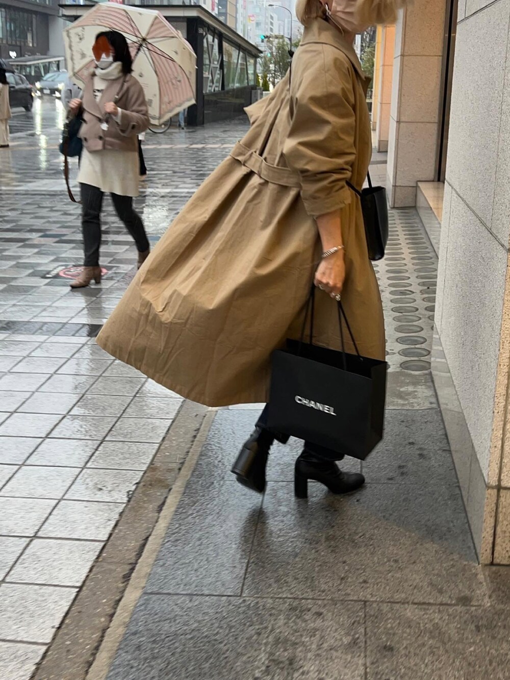 ベージュ系のトレンチコート、ブラック系のブーツ、ブルー系のデニムパンツを着用したレディースの春コーディネートの5枚目の写真