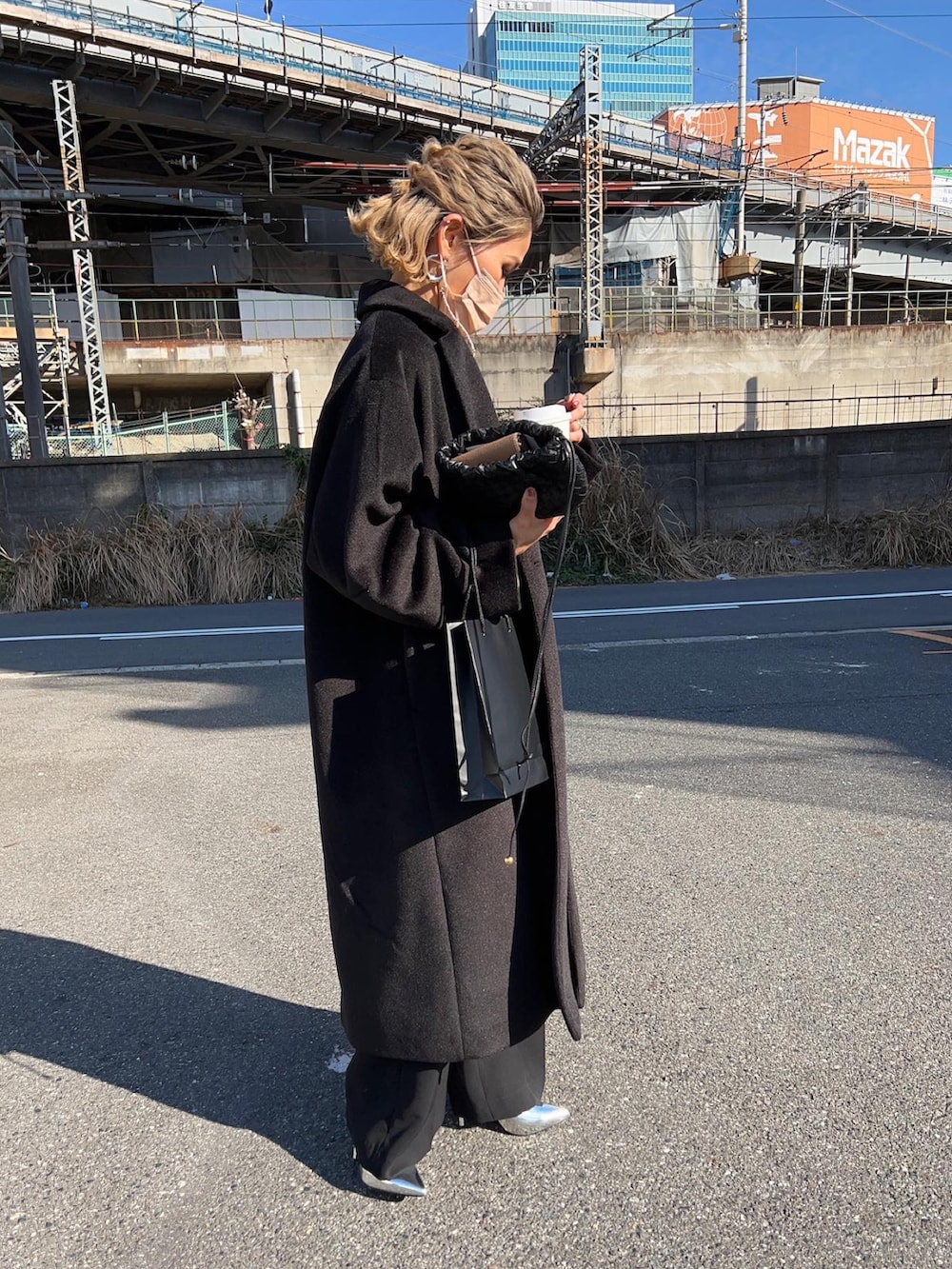 グリーン系のテーラードジャケット、ブラック系のパンツドレス、ブラック系のチェスターコートを着用したレディースの冬コーディネートの5枚目の写真