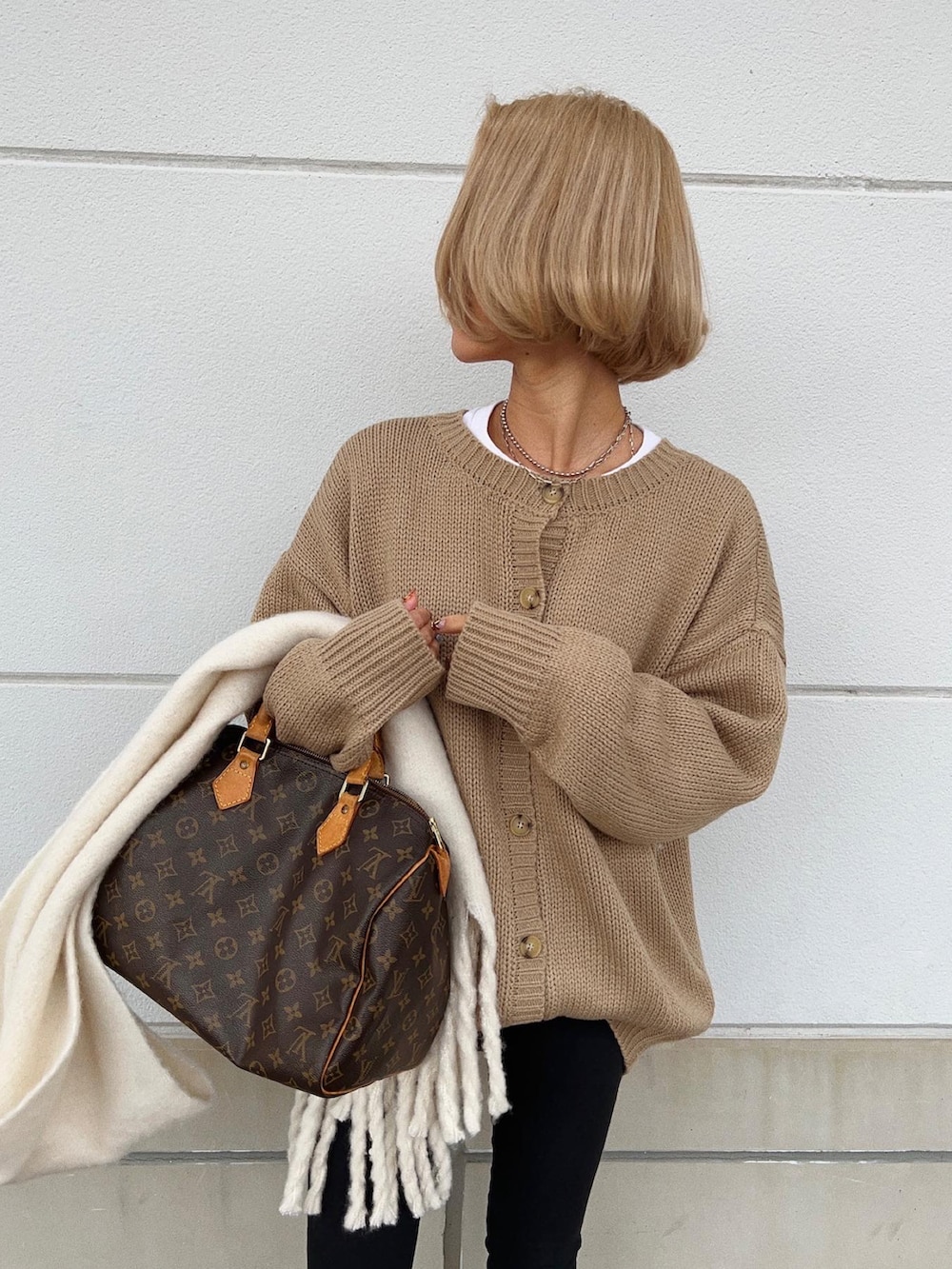 ベージュ系のカーディガン/ボレロ、ブラック系のショルダーバッグ、ブラック系のパンツを着用したレディースの冬コーディネートの5枚目の写真