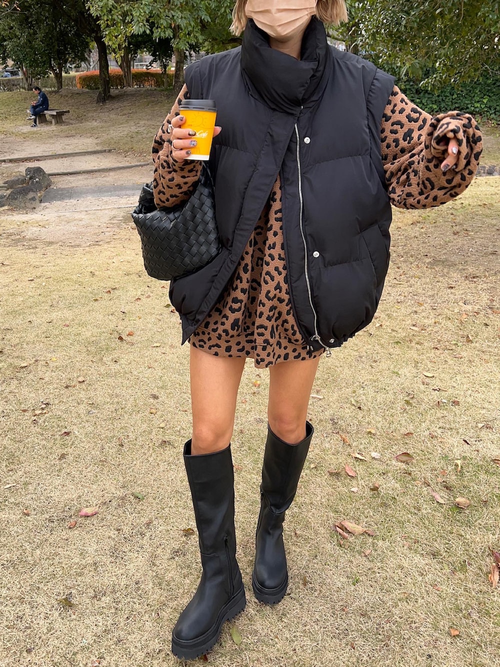 ブラック系のブーツ、ブラック系のハンドバッグ、ブラック系のベストを着用したレディースの冬コーディネートの2枚目の写真