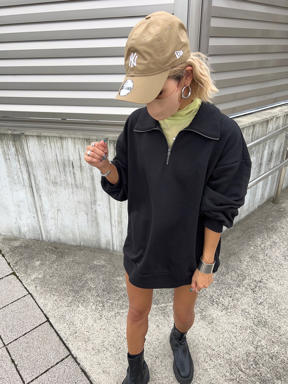 ブラック系のスウェット、グリーン系のTシャツ/カットソー、ブラック系のブーツを着用したレディースの秋コーディネートの2枚目の写真